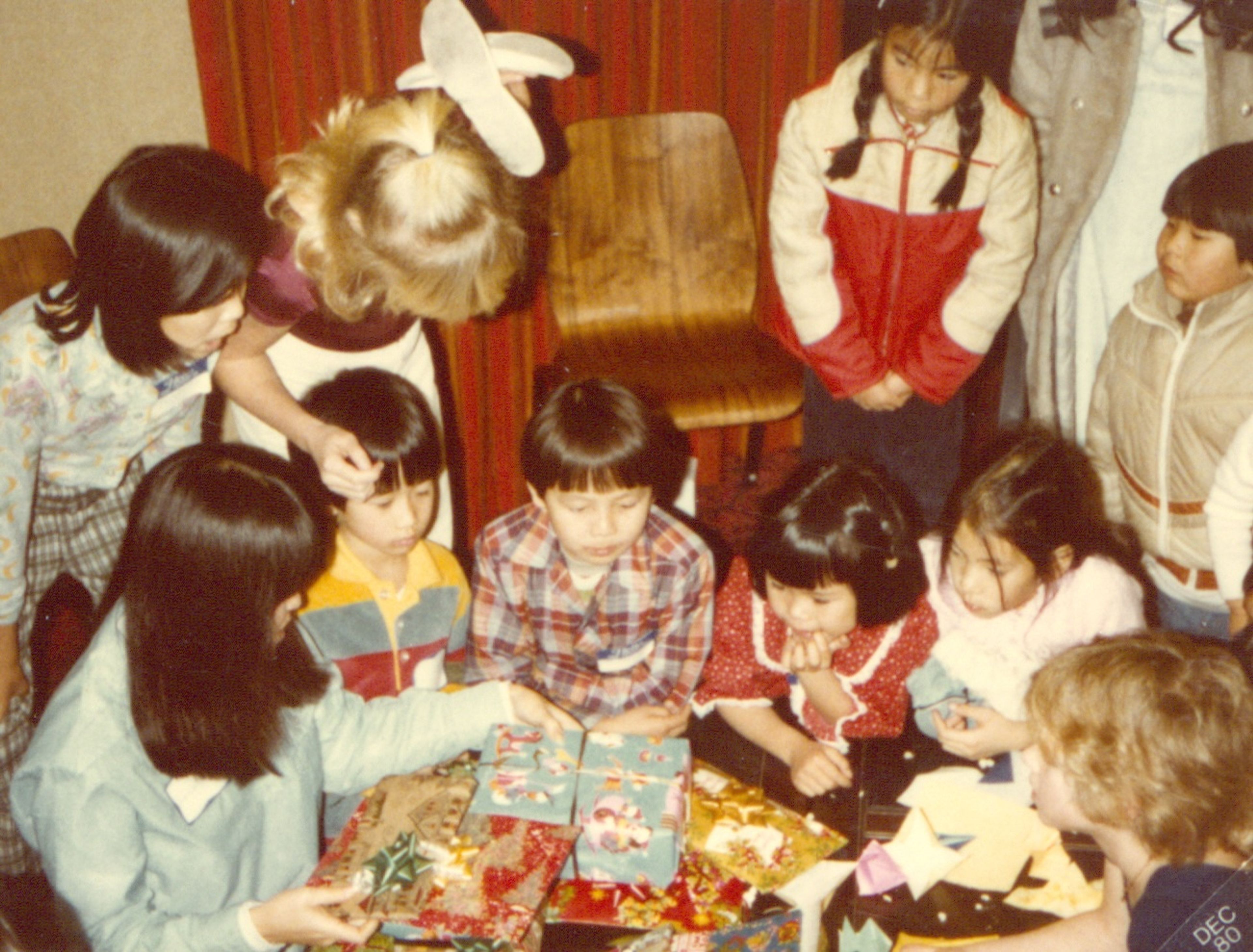 Children gather around presents at the annual PAAA holiday party, likely in the early 1980s.