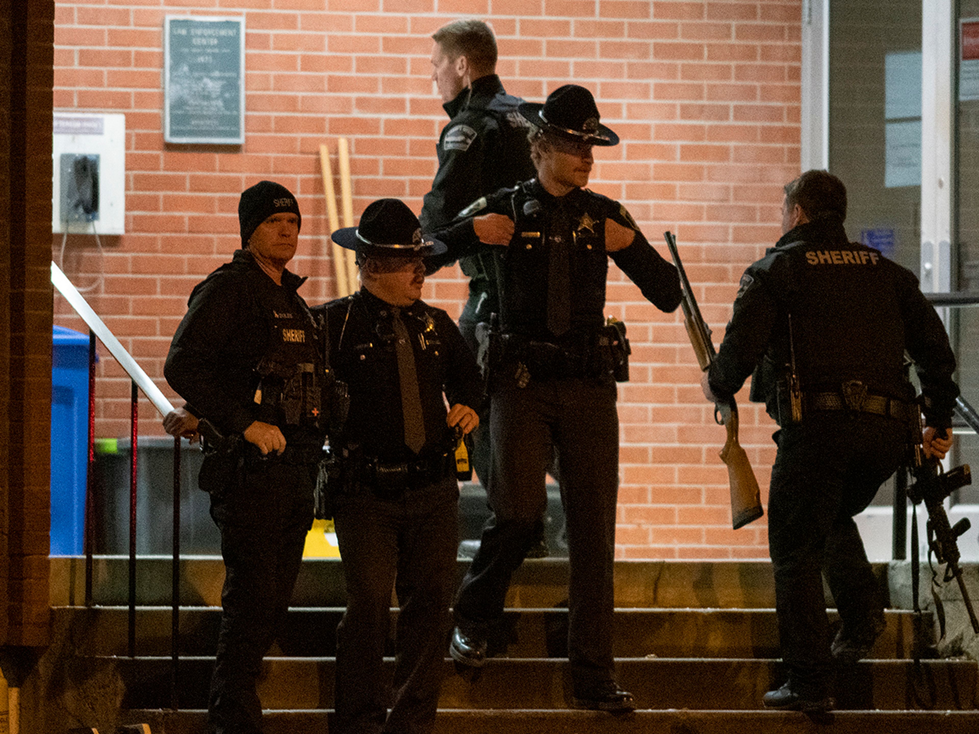 Law enforcement members stand outside of the Latah County Sherrif’s Office in Moscow after a vehicle carrying suspect Bryan Kohberger arrived on Wednesday evening.