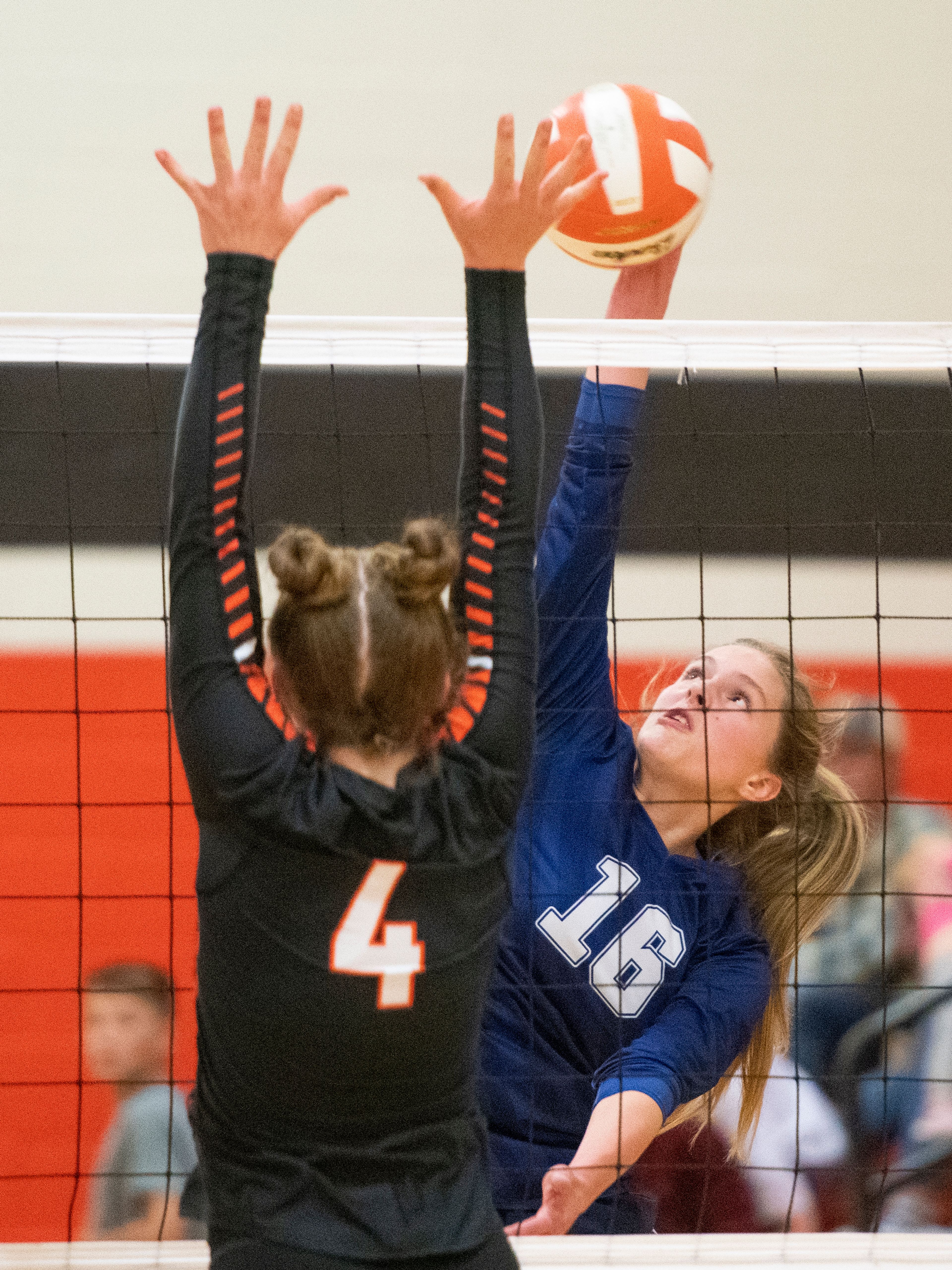 Troy’s Olivia Tyler (4) blocks a spike attempt from Logos’ Signe Holloway (16) during a Whitepine League matchup at Troy High School on Tuesday.