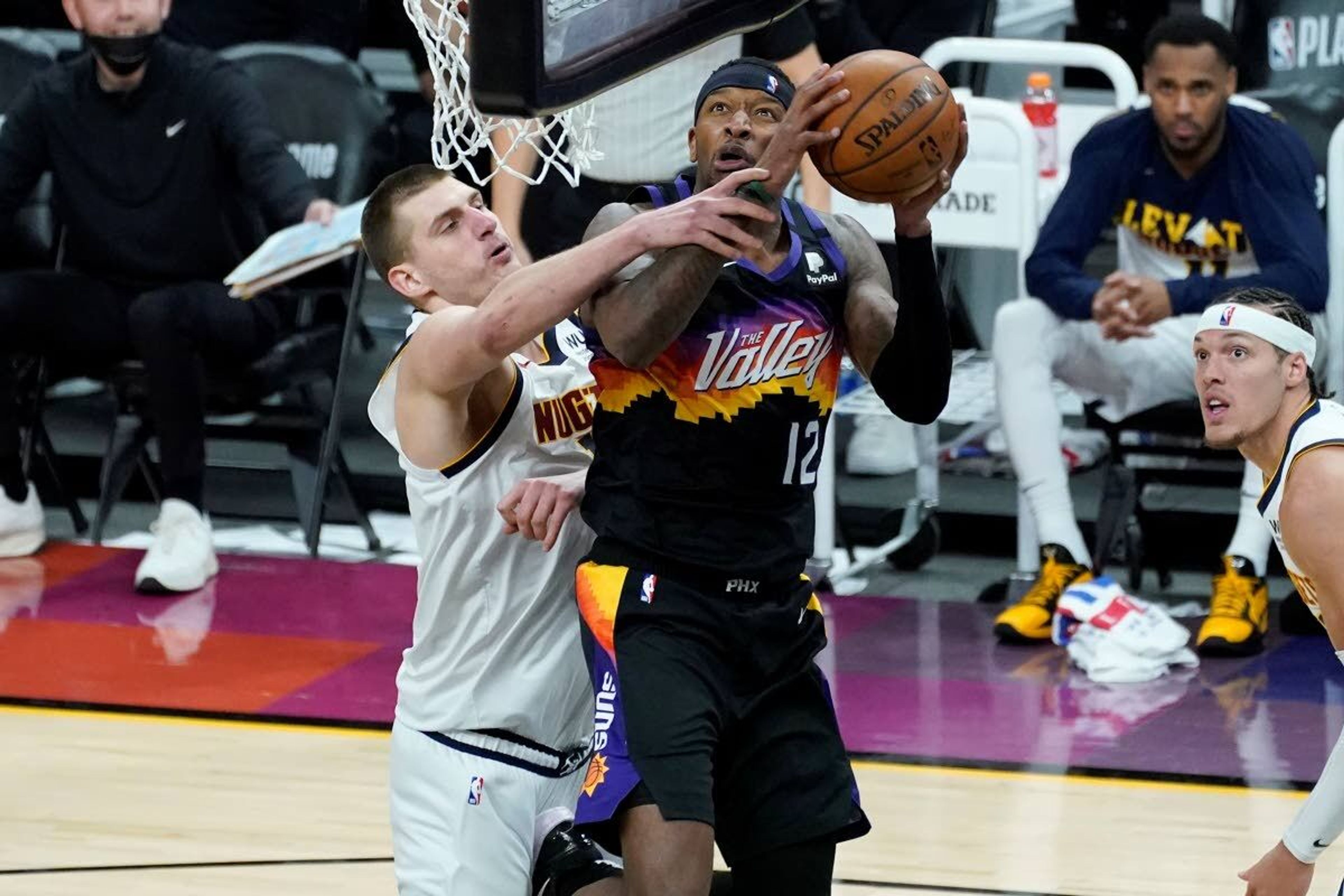 Phoenix Suns forward Torrey Craig (12) shoots as Denver Nuggets center Nikola Jokic defends during the second half of Game 1 of an NBA basketball second-round playoff series, Monday, June 7, 2021, in Phoenix. (AP Photo/Matt York)