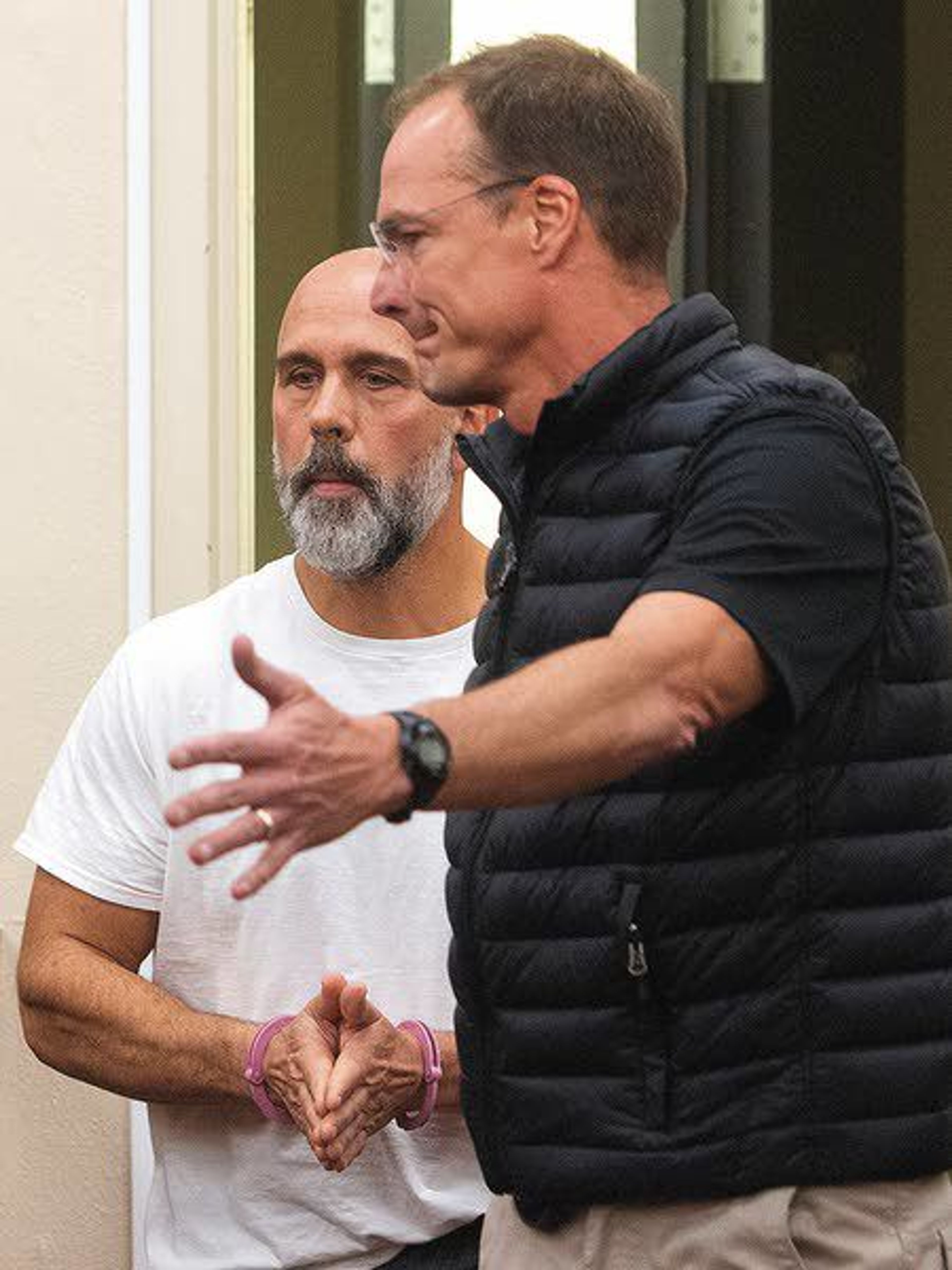 Pullman Police Department Sgt. Dan Hargraves, left, is escorted into a Whitman County Superior Court room before his arraignment hearing Tuesday afternoon at the Whitman County Courthouse in Colfax.