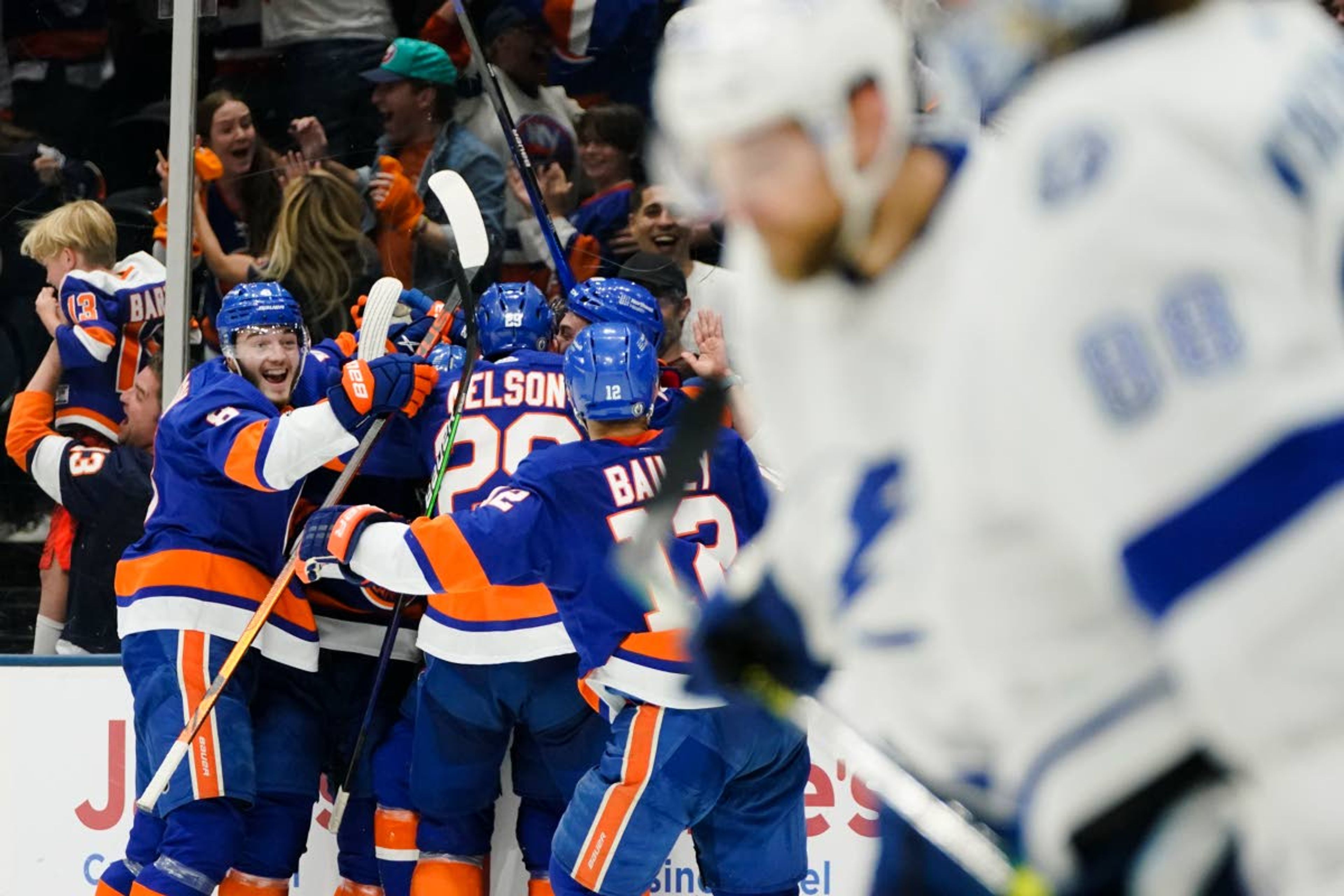 The New York Islanders celebrate an overtime goal by Anthony Beauvillier after Game 6 of an NHL hockey semifinals as Tampa Bay Lightning goaltender Andrei Vasilevskiy leaves the ice with teammates Wednesday, June 23, 2021, in Uniondale, N.Y. The Islanders won 3-2. (AP Photo/Frank Franklin II)