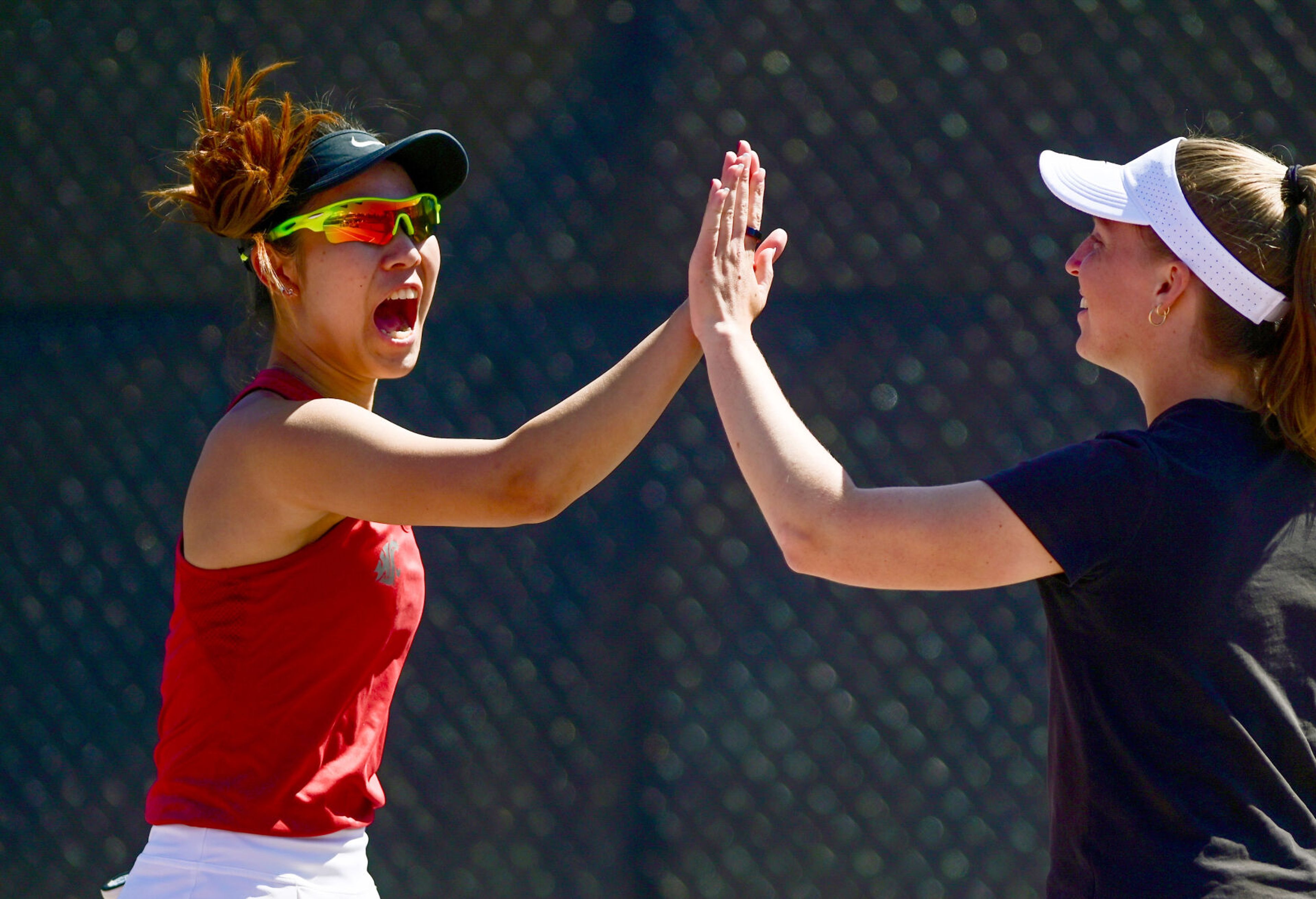 Washington State’s Yura Nakagawa, left, celebrates a match point against Washington during a doubles match with fellow Cougar Fifa Kumhom, not pictured, in Pullman on Friday.