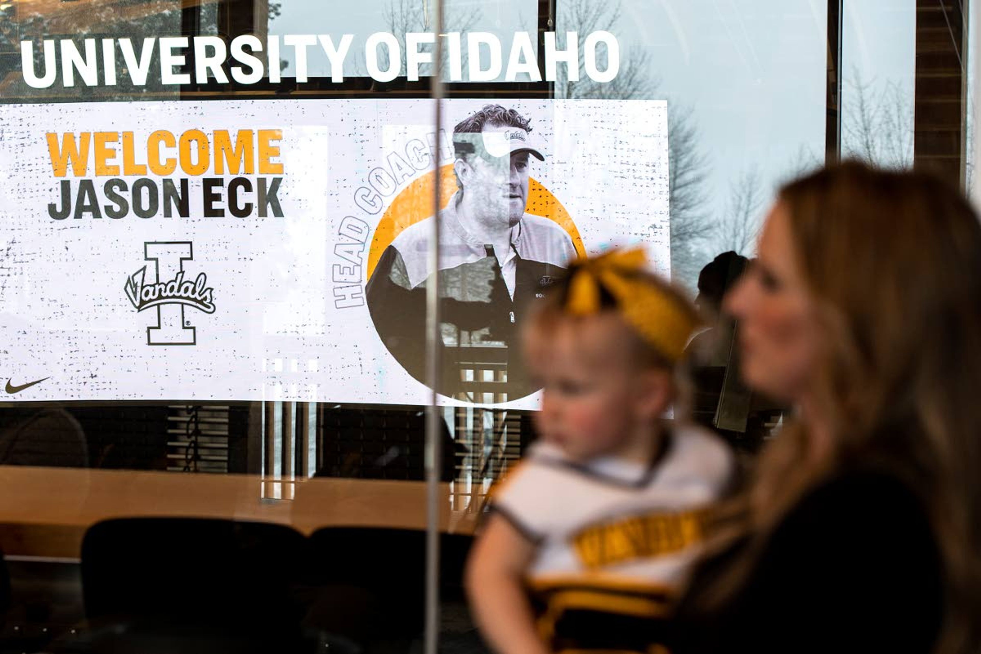 Head coach Jason Eck’s picture appears on the jumbotron inside Idaho Central Credit Union Arena behind his wife Kimberly and daughter Lola during his introductory news conference on Monday afternoon in Moscow.