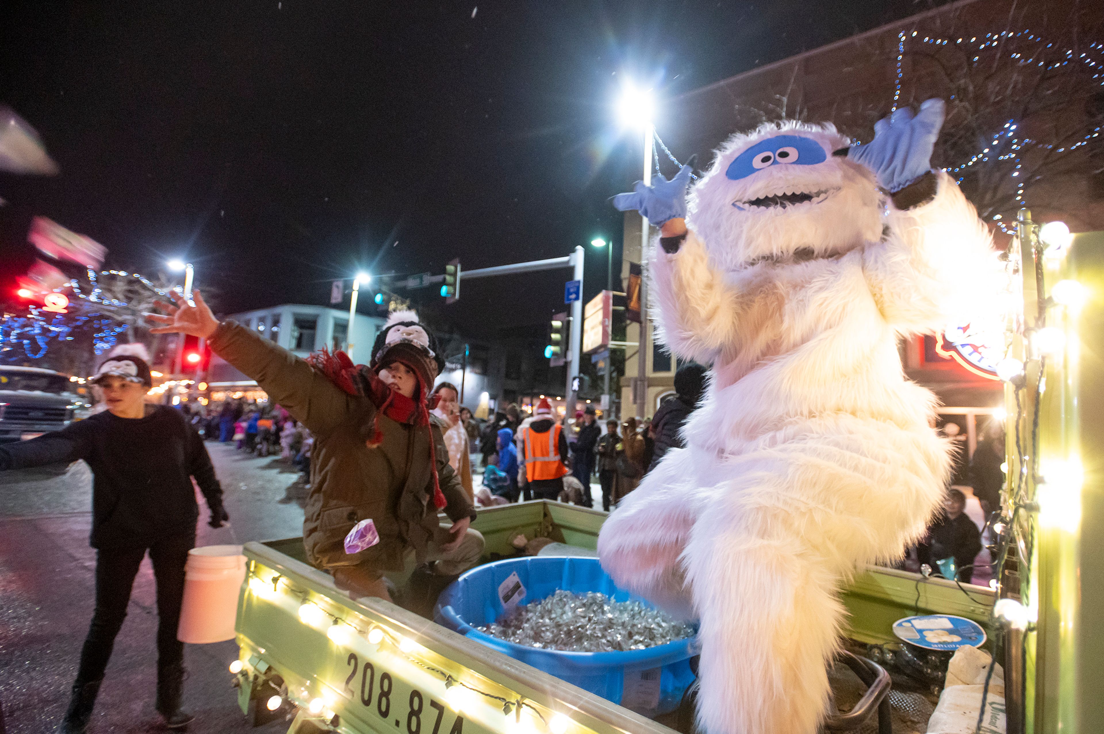 Float riders toss candy into the crowd during the Light up the Season Parade in downtown Moscow on Thursday.