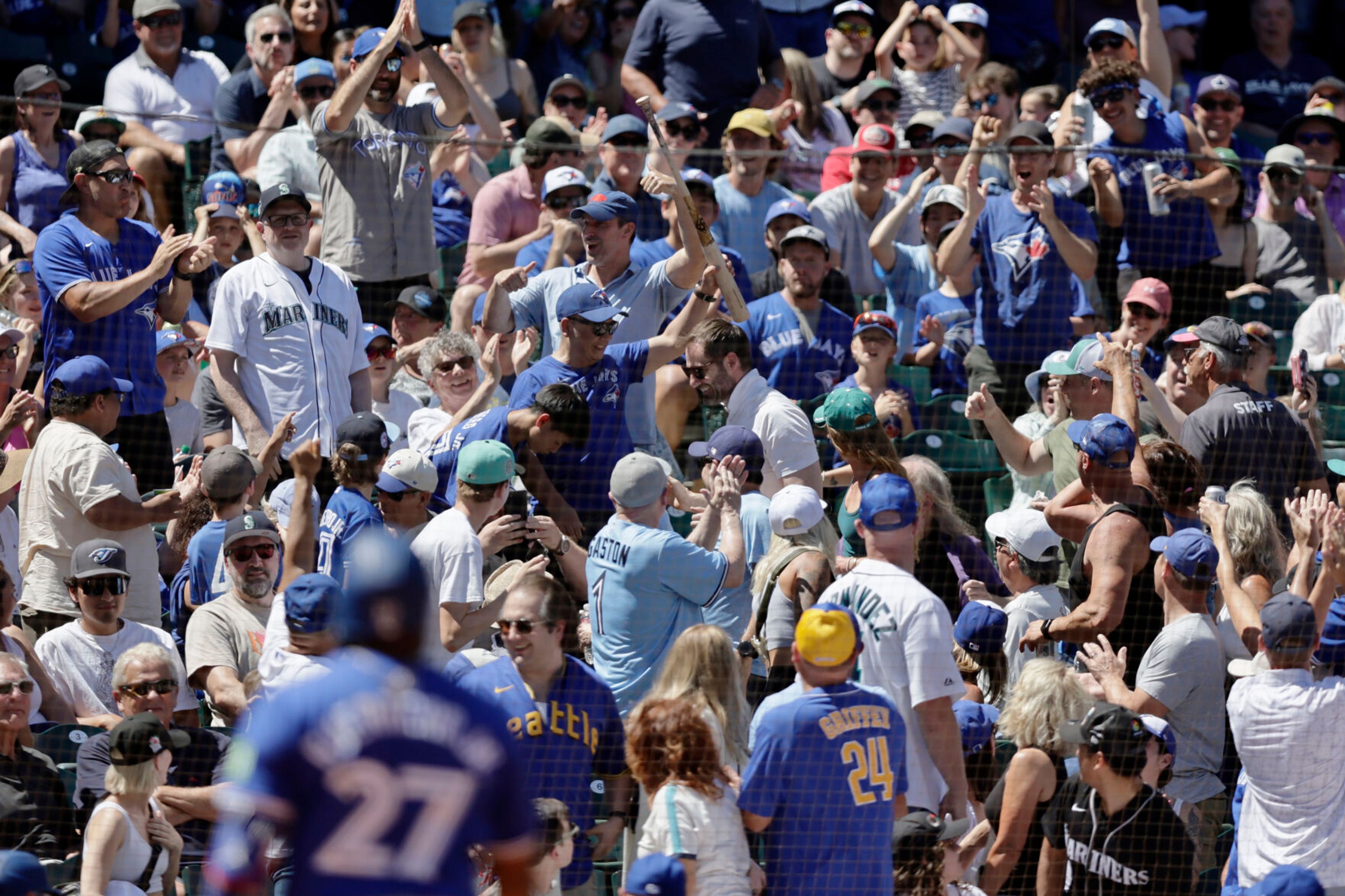 A fan holds up the bat Toronto Blue Jays' Vladimir Guerrero Jr. lost on a swing during the fifth inning in a baseball game against the Seattle Mariners, Saturday, July 6, 2024, in Seattle. (AP Photo/John Froschauer)