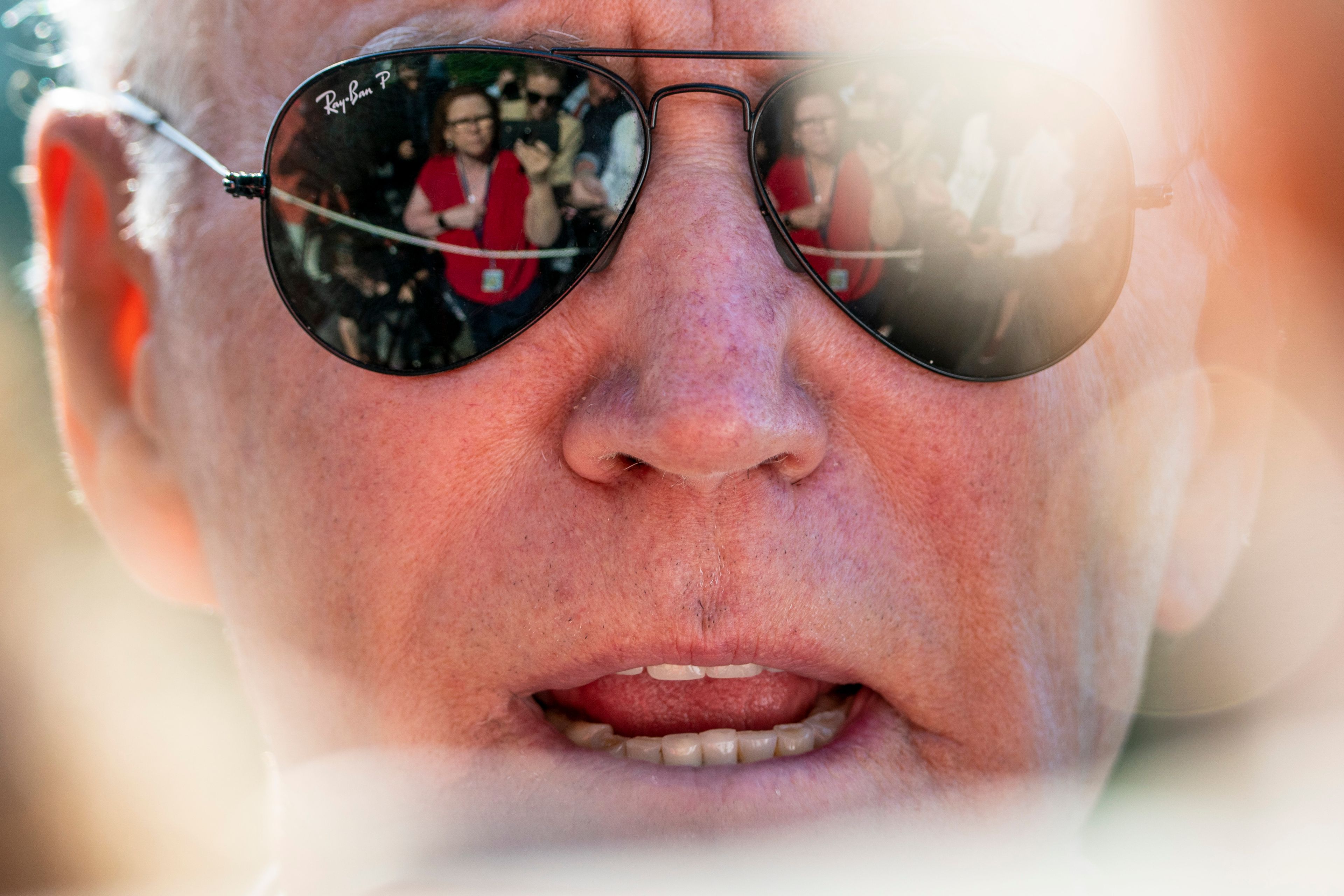 Members of the media are visible in the sunglasses of President Joe Biden as he speaks on the South Lawn of the White House in Washington, Monday, May 30, 2022, after returning from Wilmington, Del. (AP Photo/Andrew Harnik)