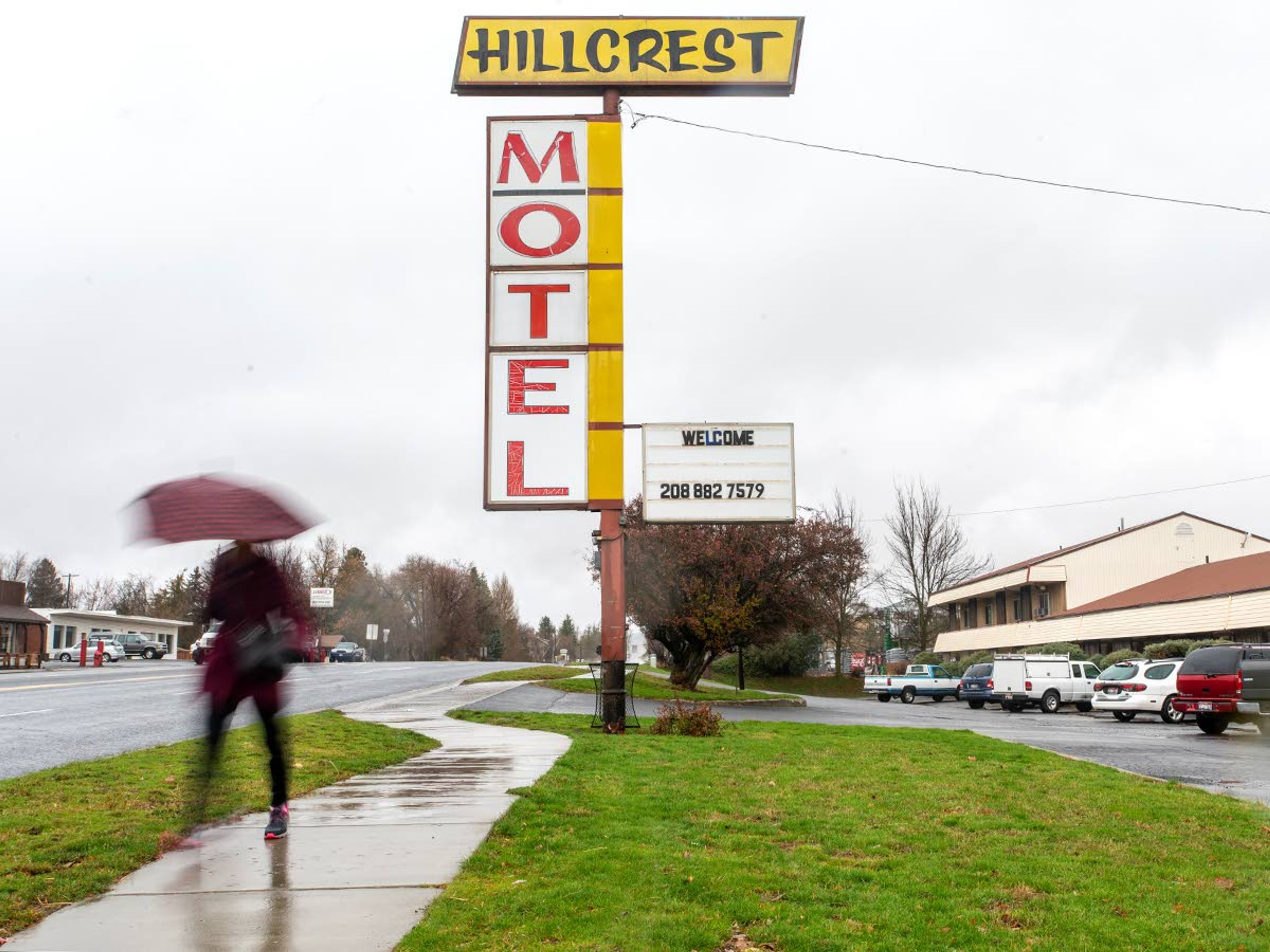 A pedestrian is seen carrying an umbrella past Hillcrest Motel on U.S. Highway 95 at a shutter speed of 1/5th of a second on a rainy day in Moscow.