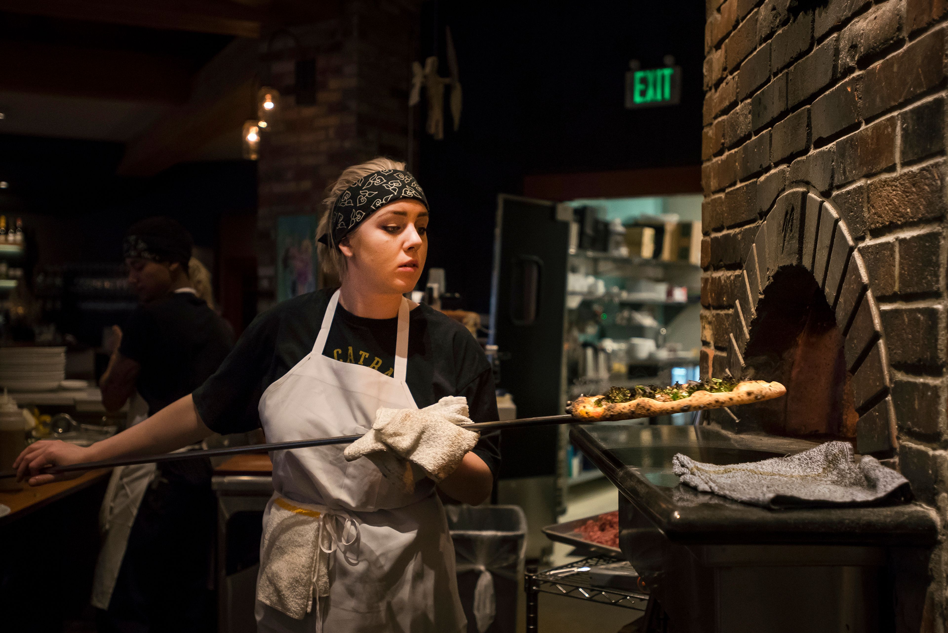 Cook Abbi Dahlin takes a freshly cooked pizza out of the wood fire oven at Maialina Pizzeria Napoletana onNov. 15 in Moscow.