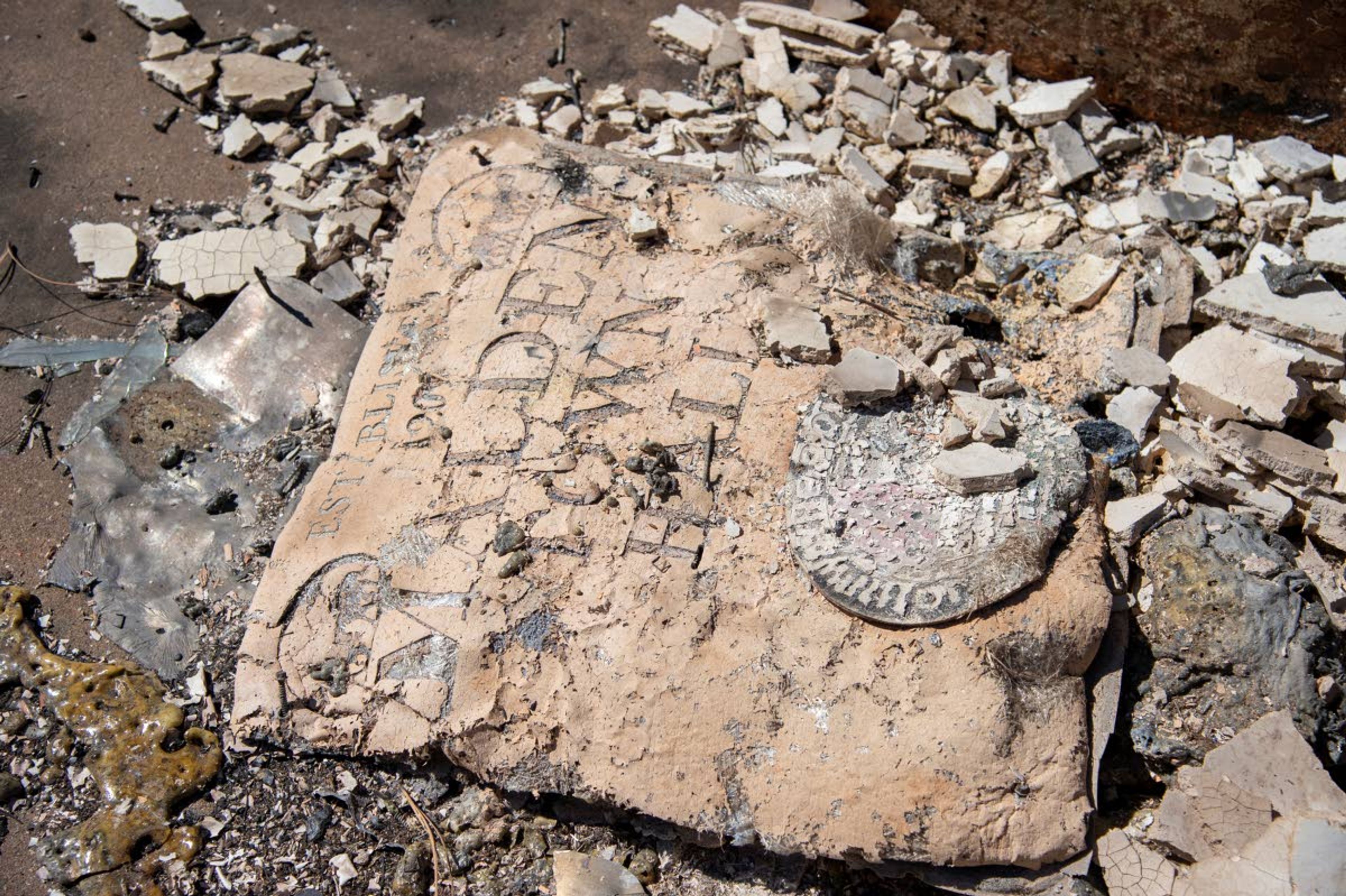 A sign reading "Malden Town Hall" lies in the ashes of the former library and city hall building Tuesday in Malden, Wash., the day after a fast-moving wildfire swept through the tiny town west of Rosalia.