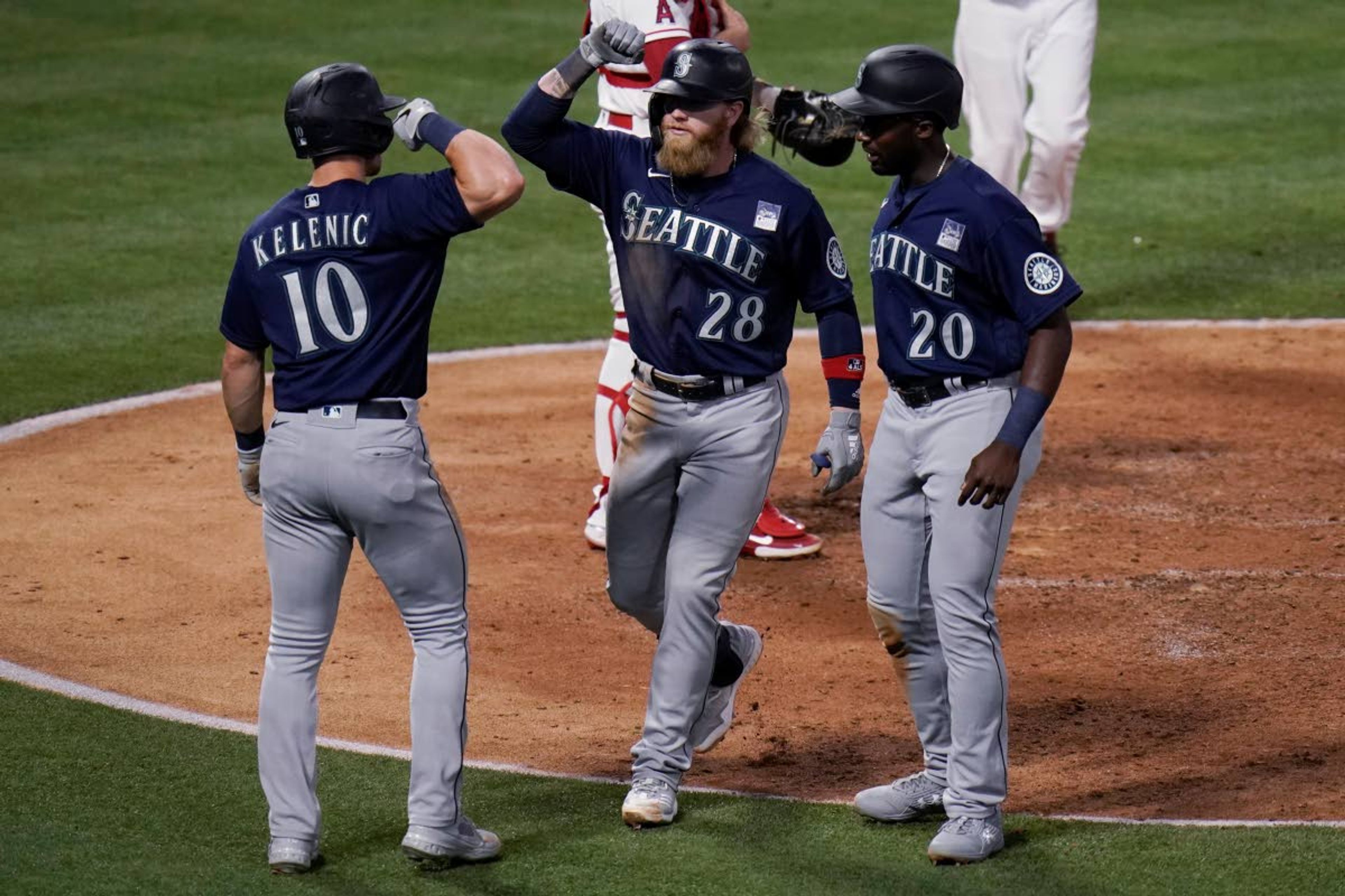 Seattle Mariners' Jake Fraley, center, celebrates his three-run home run with Jarred Kelenic, left, and Taylor Trammell during the fourth inning of a baseball game against the Los Angeles Angels in Anaheim, Calif., Thursday, June 3, 2021. (AP Photo/Jae C. Hong)