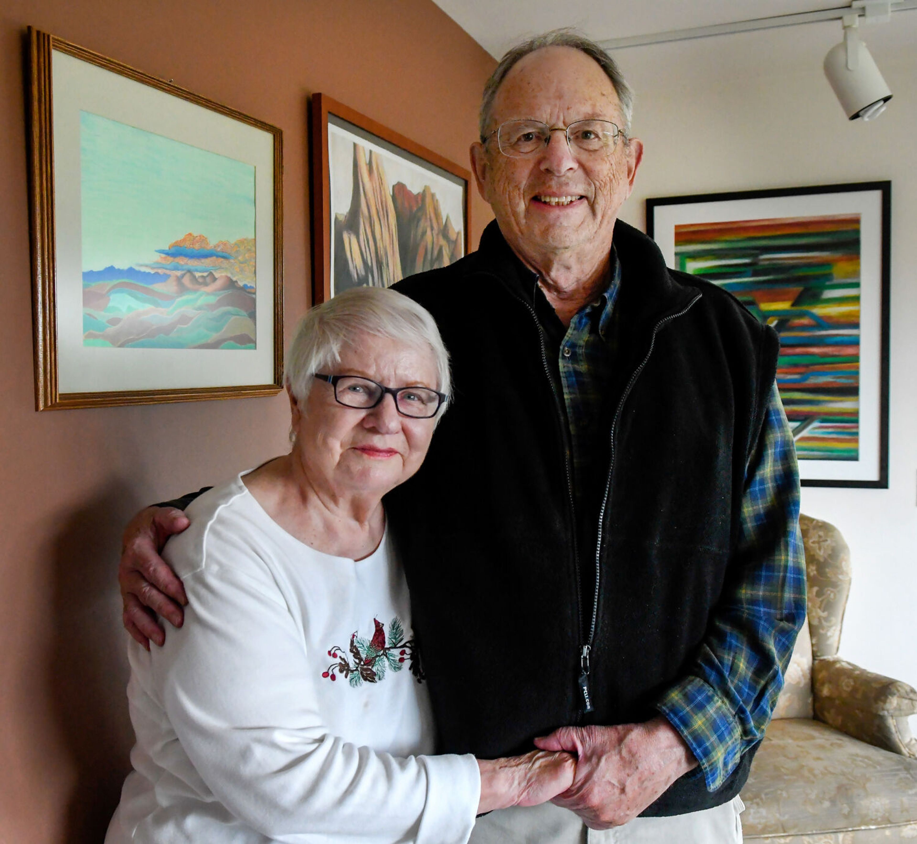 Karen and Nick Kiessling, parents of Dan Kiessling, stand in front of framed pieces of Dan’s artwork at their home in Pullman on Tuesday. A collection of Dan’s Palouse County pastels will be shown at a celebration of life art show in his honor on June 22 at the Bank Left Art Gallery in Palouse.