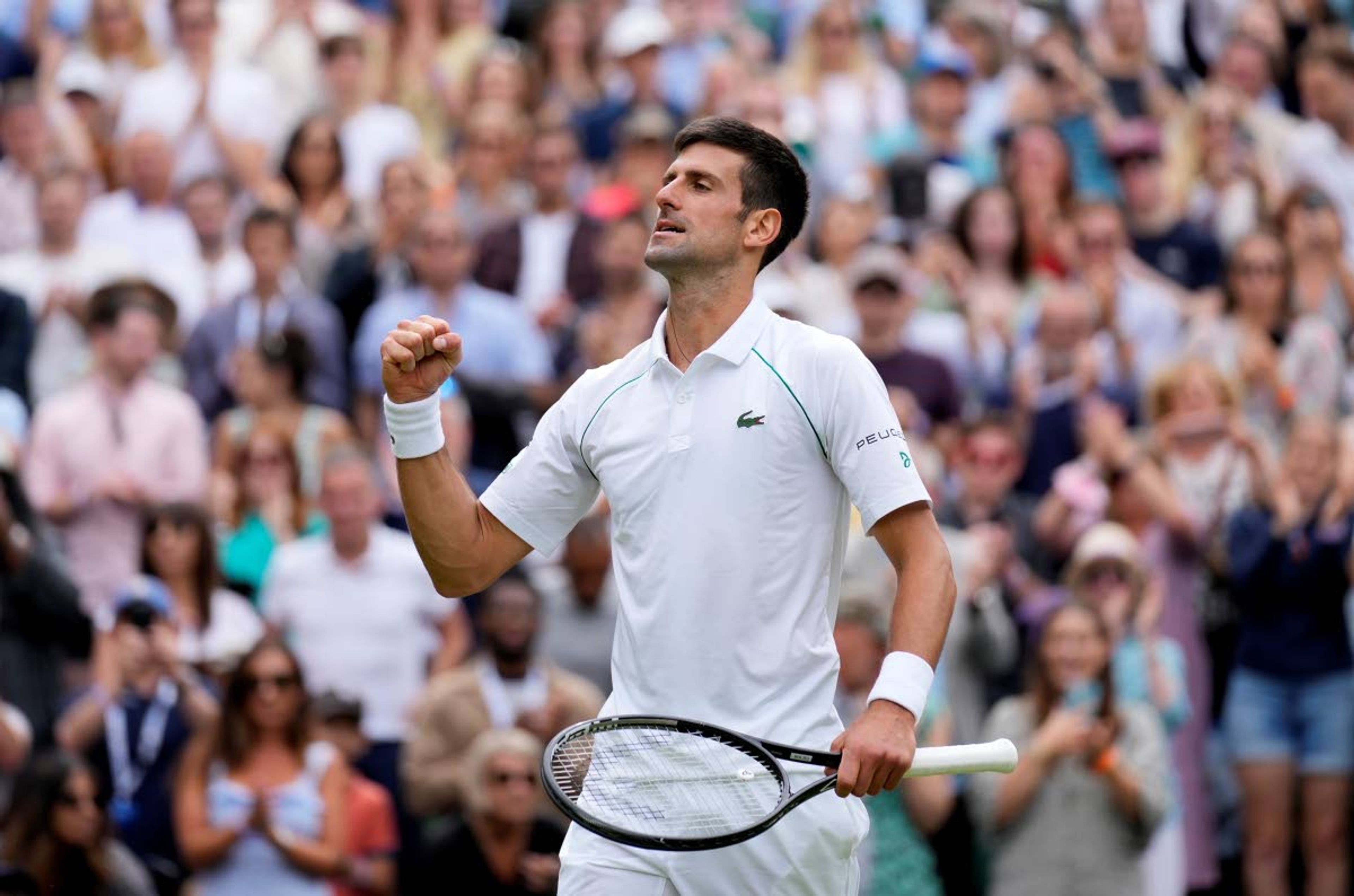 Serbia's Novak Djokovic celebrates after defeating Chile's Cristian Garin during the men's singles fourth round match on day seven of the Wimbledon Tennis Championships in London, Monday, July 5, 2021. (AP Photo/Kirsty Wigglesworth)