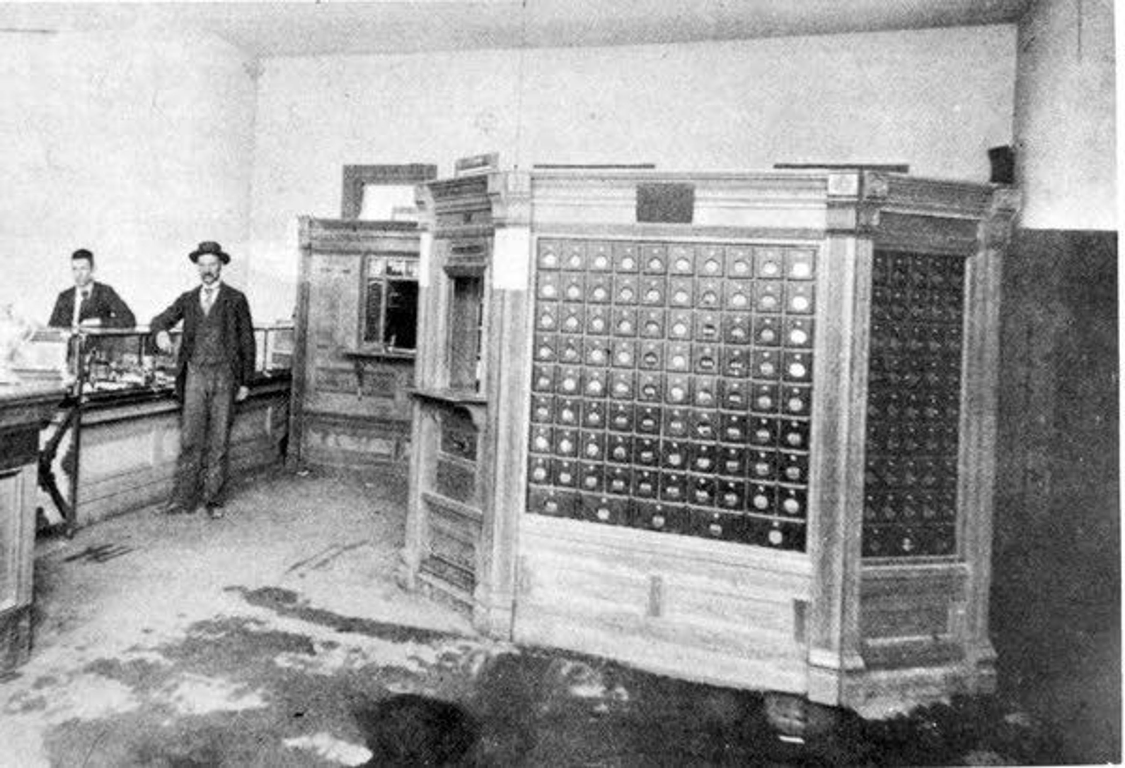 Whitman County Historical SocietyJohn T. Lobaugh (with hat), Pullman’s third postmaster, owned the 138 lock boxes he managed along with his stationery business on Main Street in the 1890s.