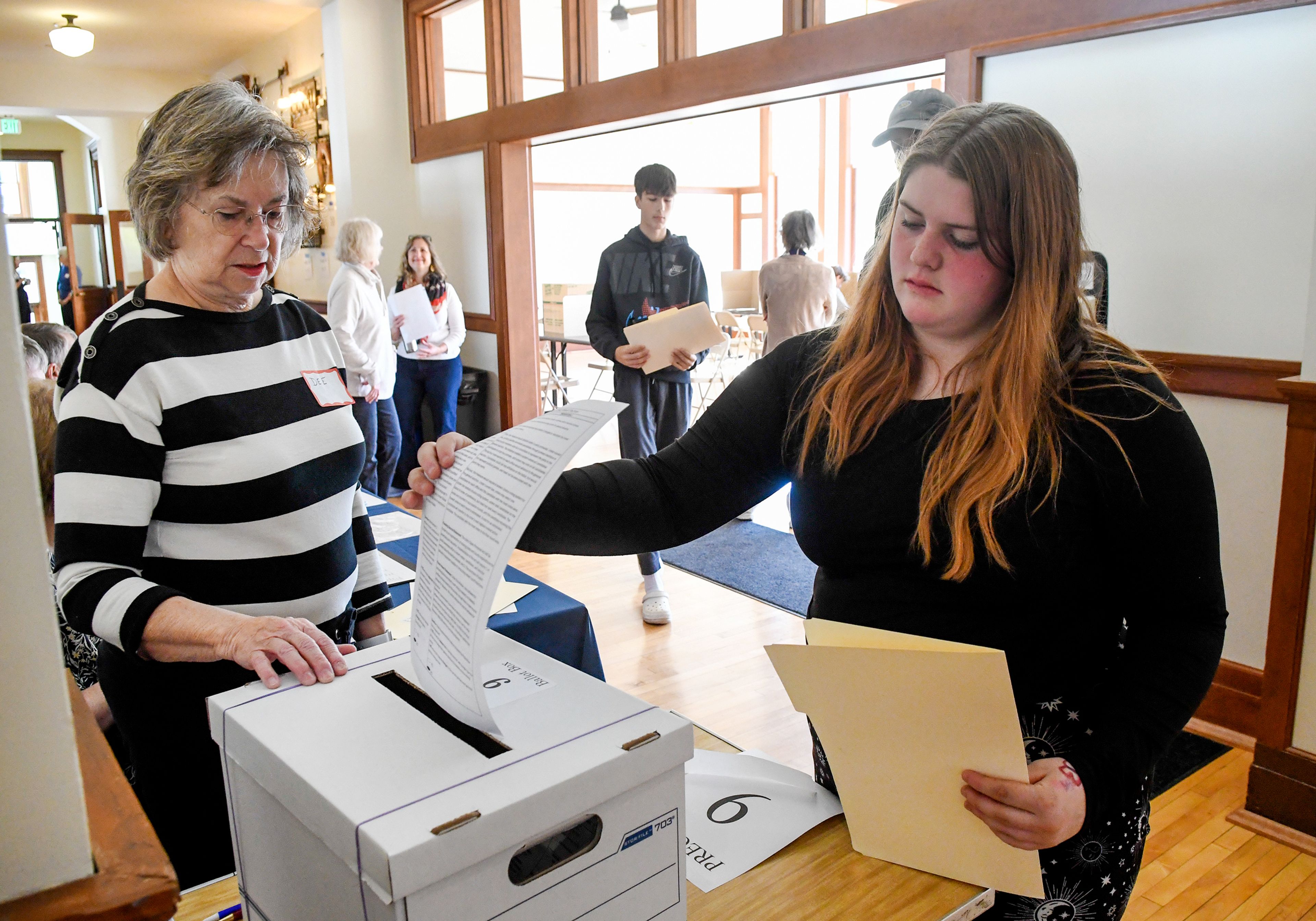 Dee Blair, left, a volunteer with the League of Women Voters of Moscow, directs Moscow High School freshman Brooklyn Daniels to the ballot box during a mock election for students Wednesday at the 1912 Center in Moscow.