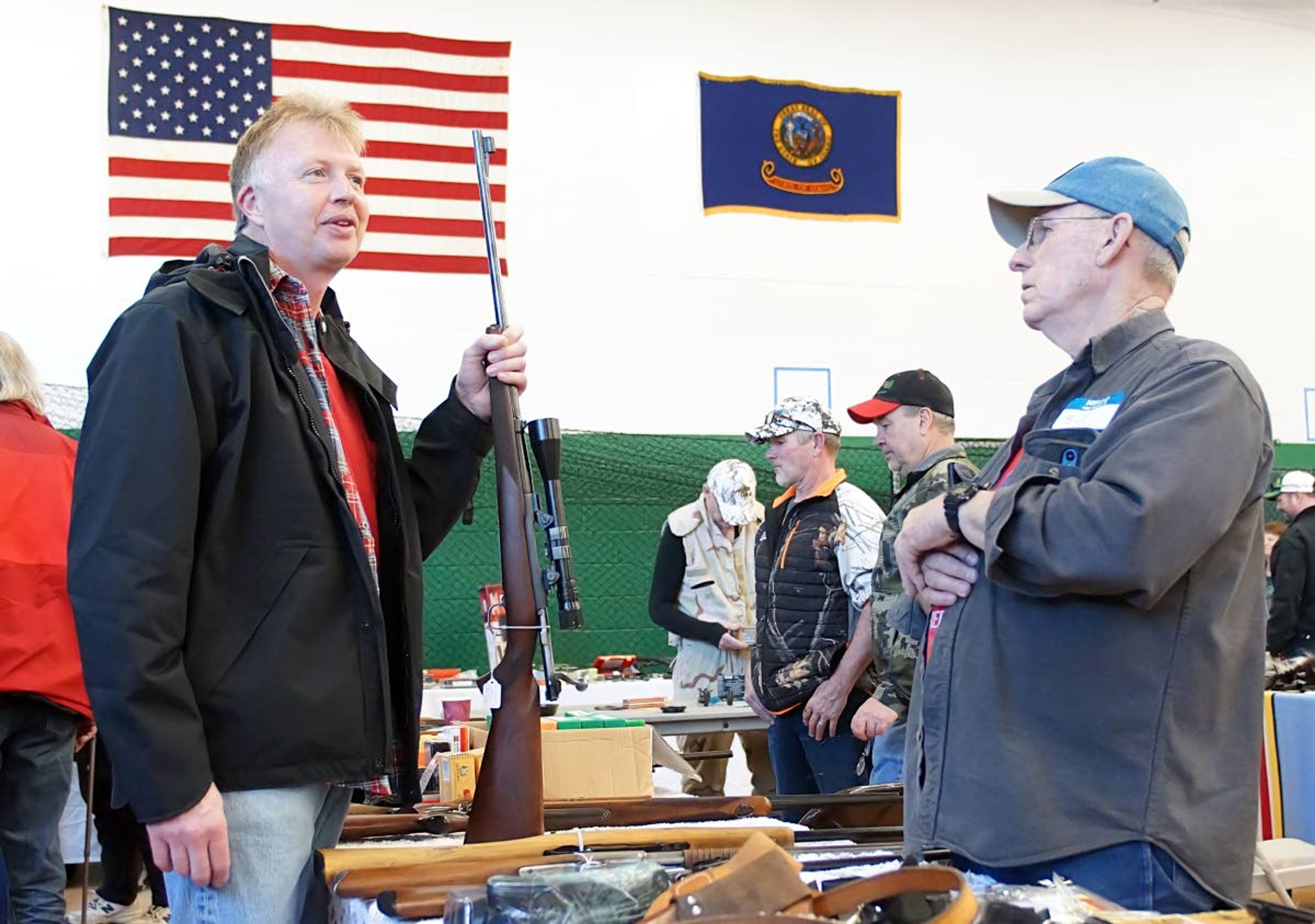 Guy Mullen, left, holds a Winchester Model 70 30-06 while talking to Potlatch Gun Show vendor Bill Rupp Sunday afternoon.