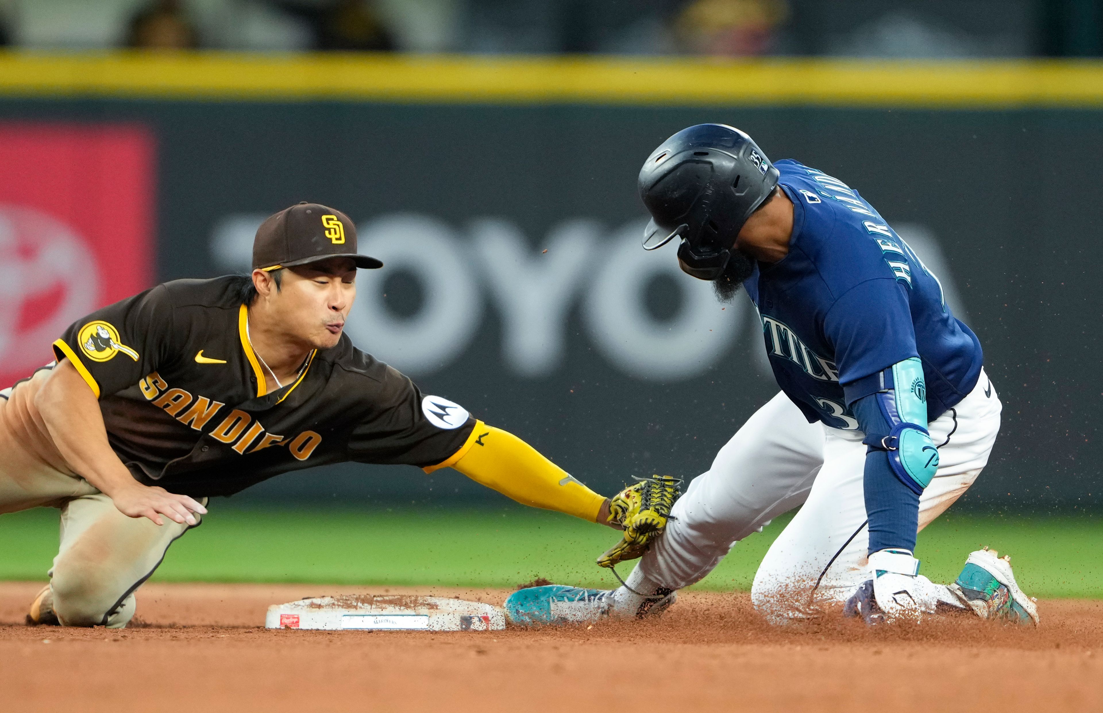 Padres second baseman Ha-Seong Kim tags out the Mariners' Teoscar Hernandez at second base as Hernandez tries to stretch his single into a double during the sixth inning of a game Wednesday in Seattle.