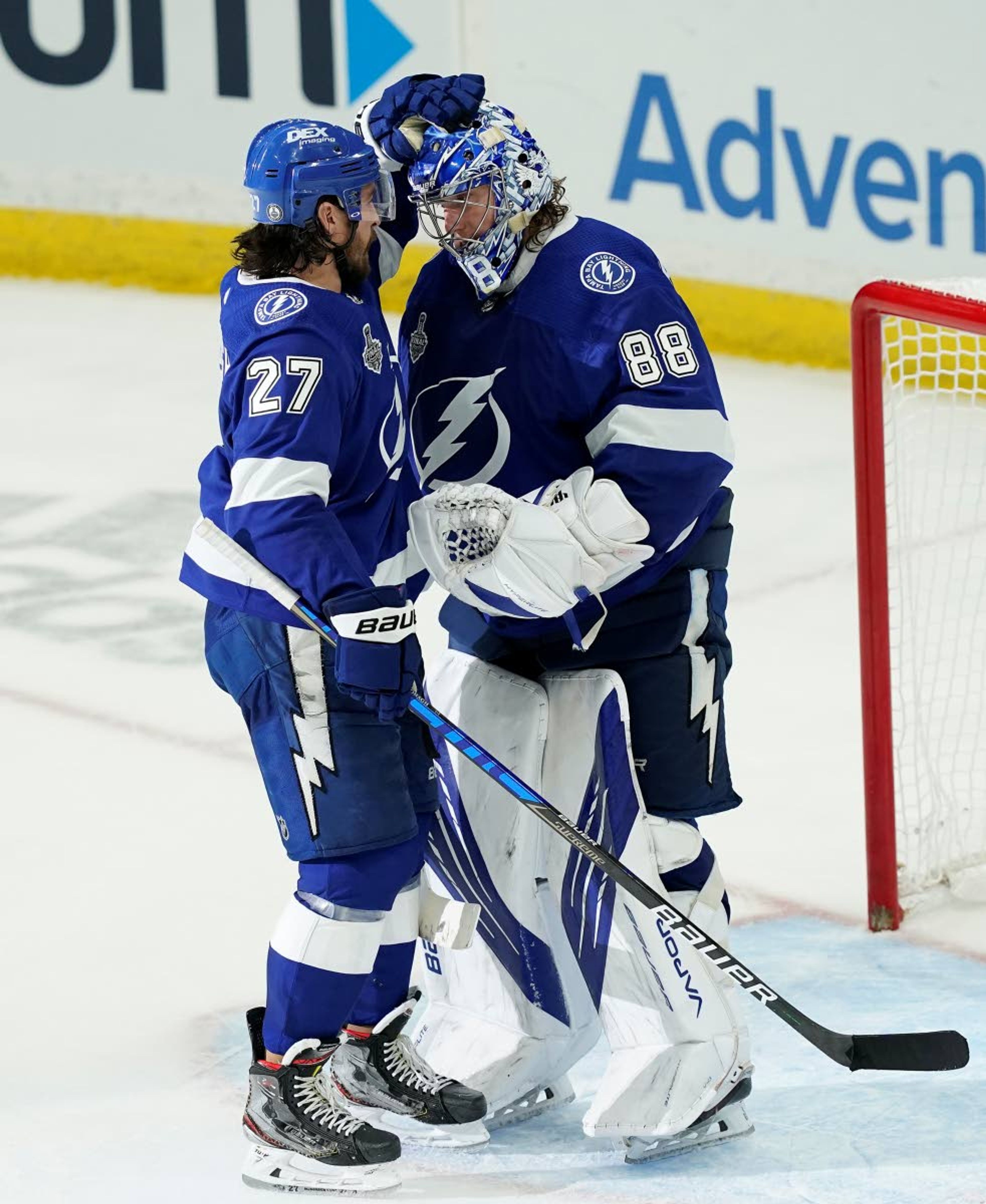 Tampa Bay Lightning defenseman Ryan McDonagh (27) pats goaltender Andrei Vasilevskiy's helmet after the third period in Game 1 of the NHL hockey Stanley Cup finals against the Montreal Canadiens, Monday, June 28, 2021, in Tampa, Fla. (AP Photo/Gerry Broome)