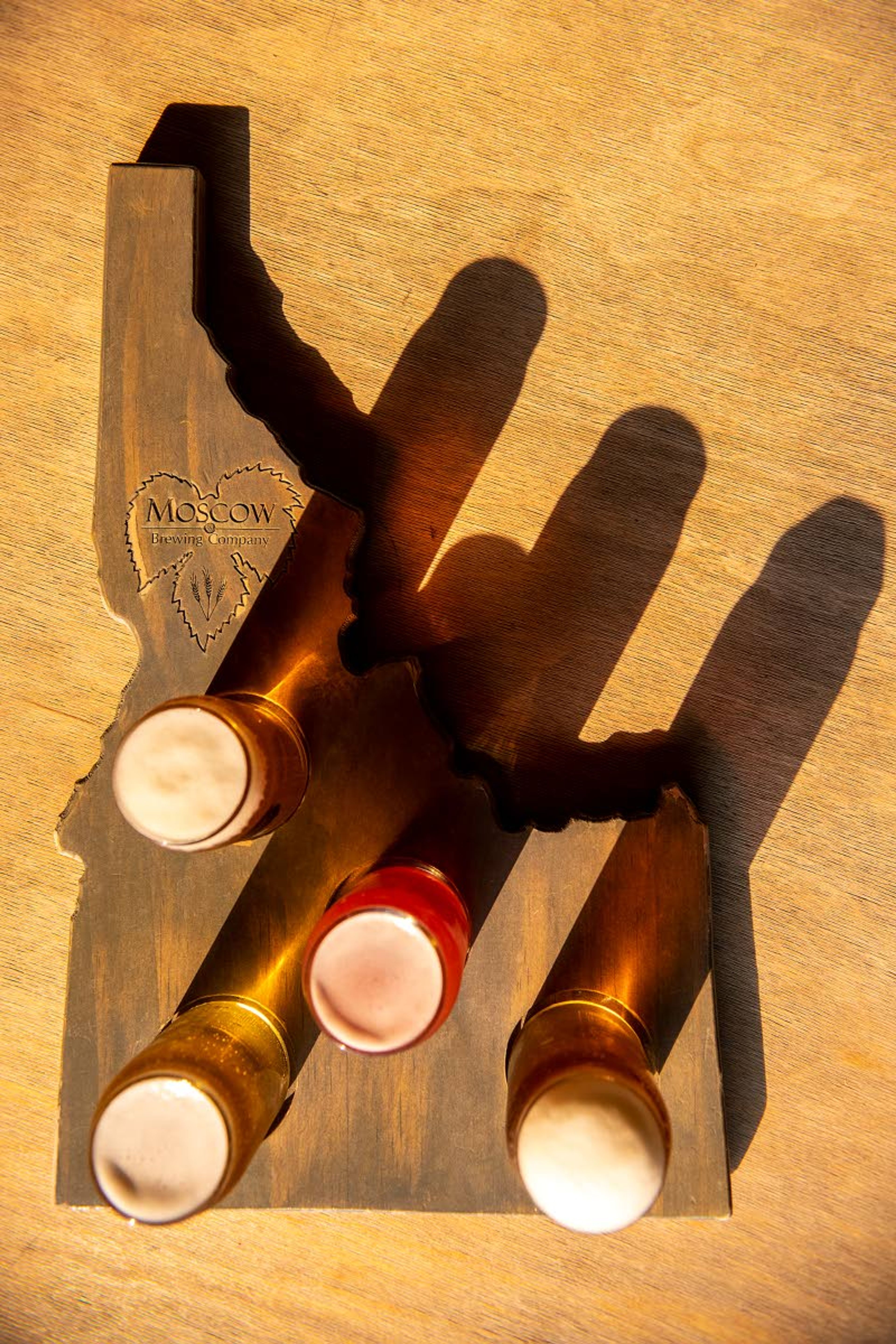 A flight of beer including a kölsch, from left, pale ale, saison and IPA are displayed on an Idaho shaped drink carrier at Moscow Brewing Company along North Almon Street in Moscow.