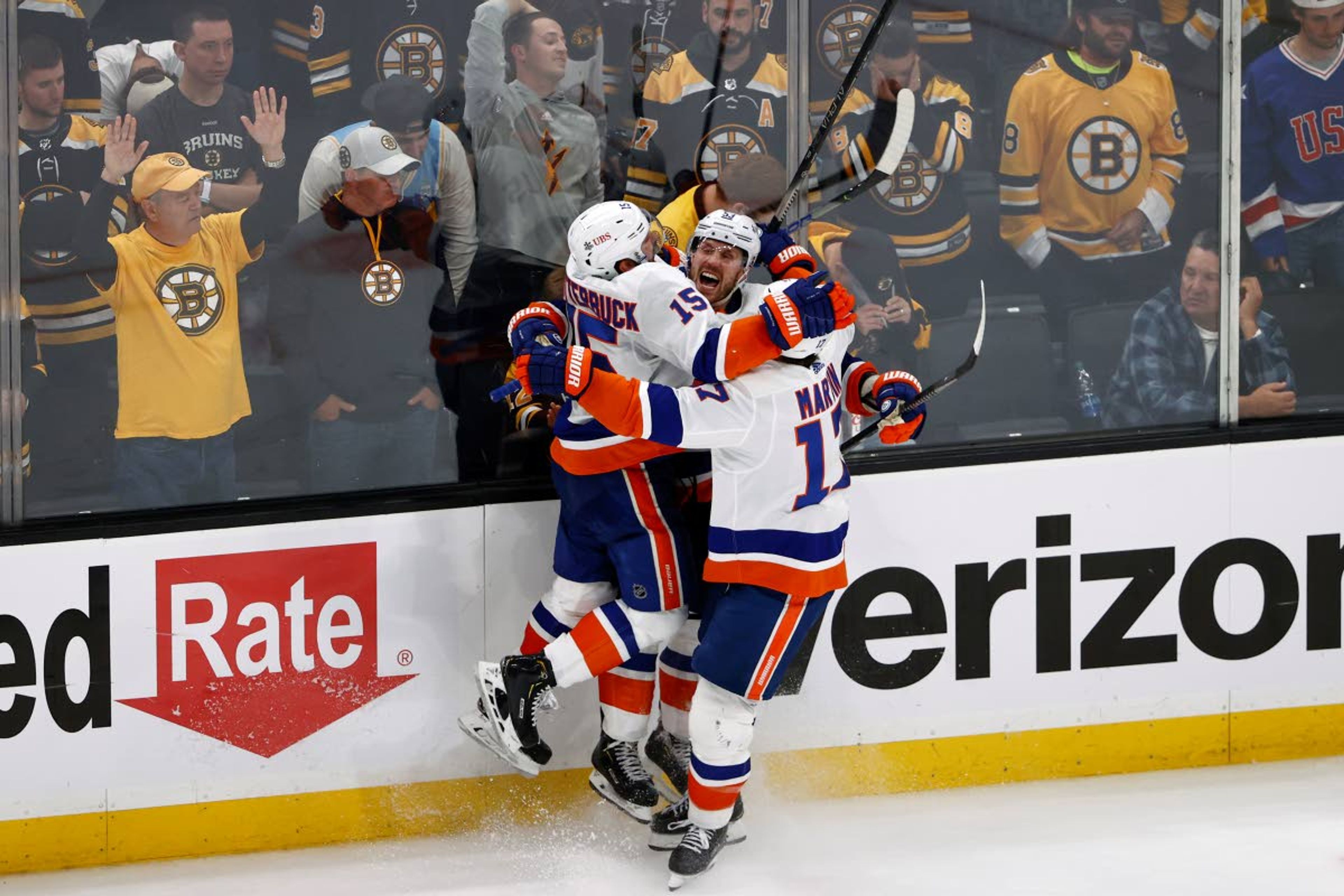 As Boston Bruins fans look on, New York Islanders' Casey Cizikas celebrates his winning goal in overtime with teammates Matt Martin (17) and Cal Clutterbuck (15) during Game 2 of an NHL hockey second-round playoff series , Monday, May 31, 2021, in Boston. (AP Photo/Winslow Townson)