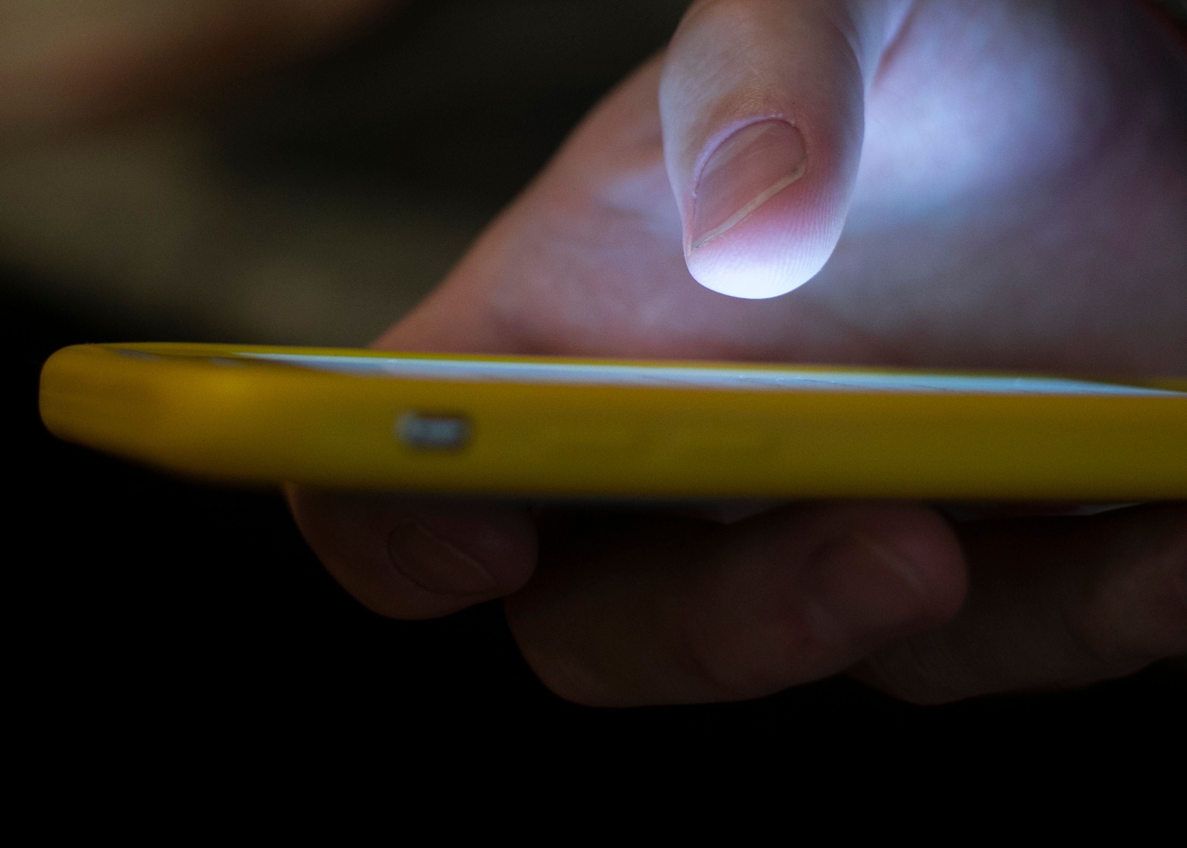 In this photo taken in 2019, a man uses a cell phone in New Orleans. Quick help for suicidal thoughts and other mental health emergencies is now as easy as 9-8-8 after the United States rolled out its first nationwide three-digit mental health crisis hotline Saturday.