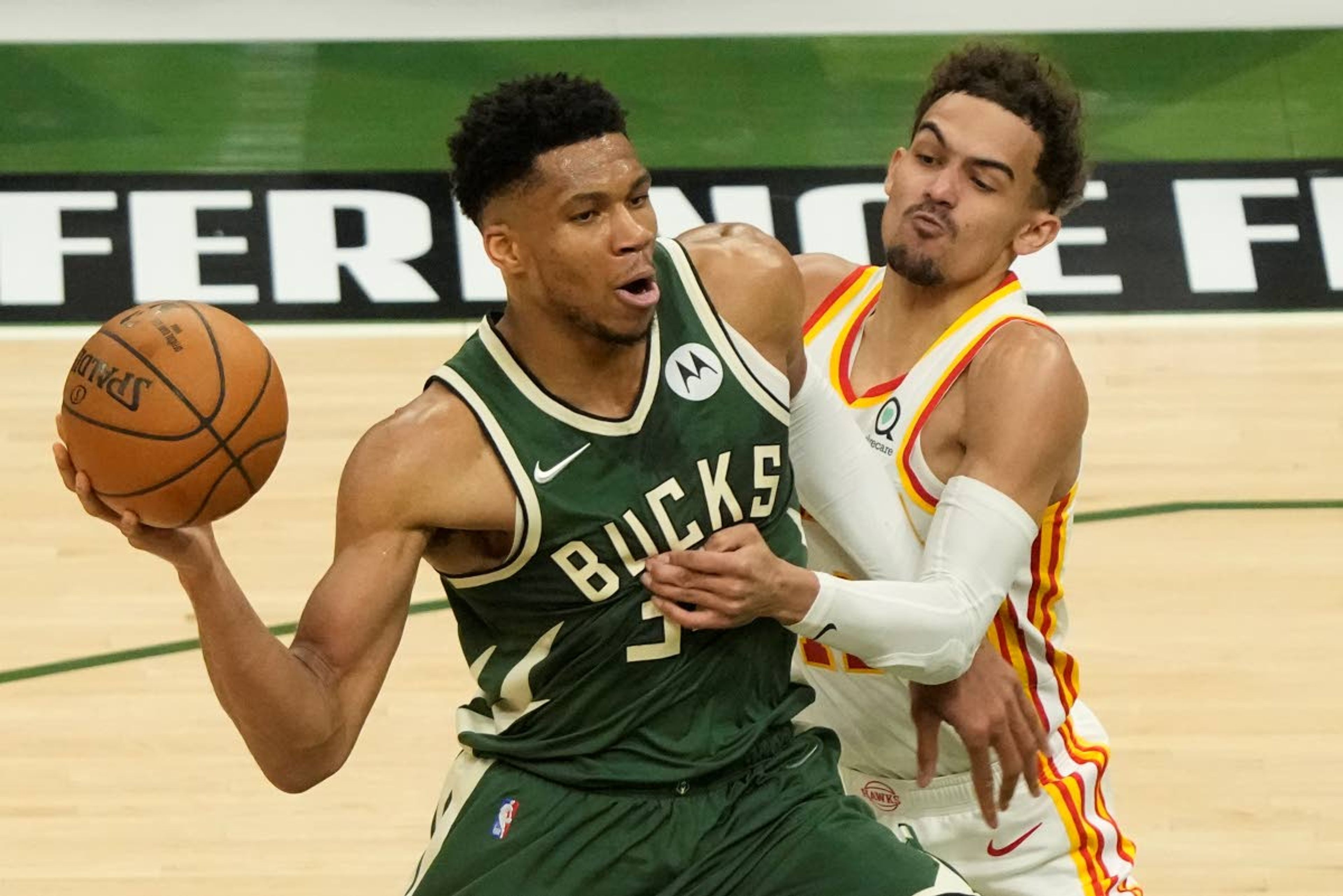 Milwaukee Bucks' Giannis Antetokounmpo tries to get past Atlanta Hawks' Trae Young during the first half of Game 1 of the NBA Eastern Conference basketball finals game Wednesday, June 23, 2021, in Milwaukee. (AP Photo/Morry Gash)