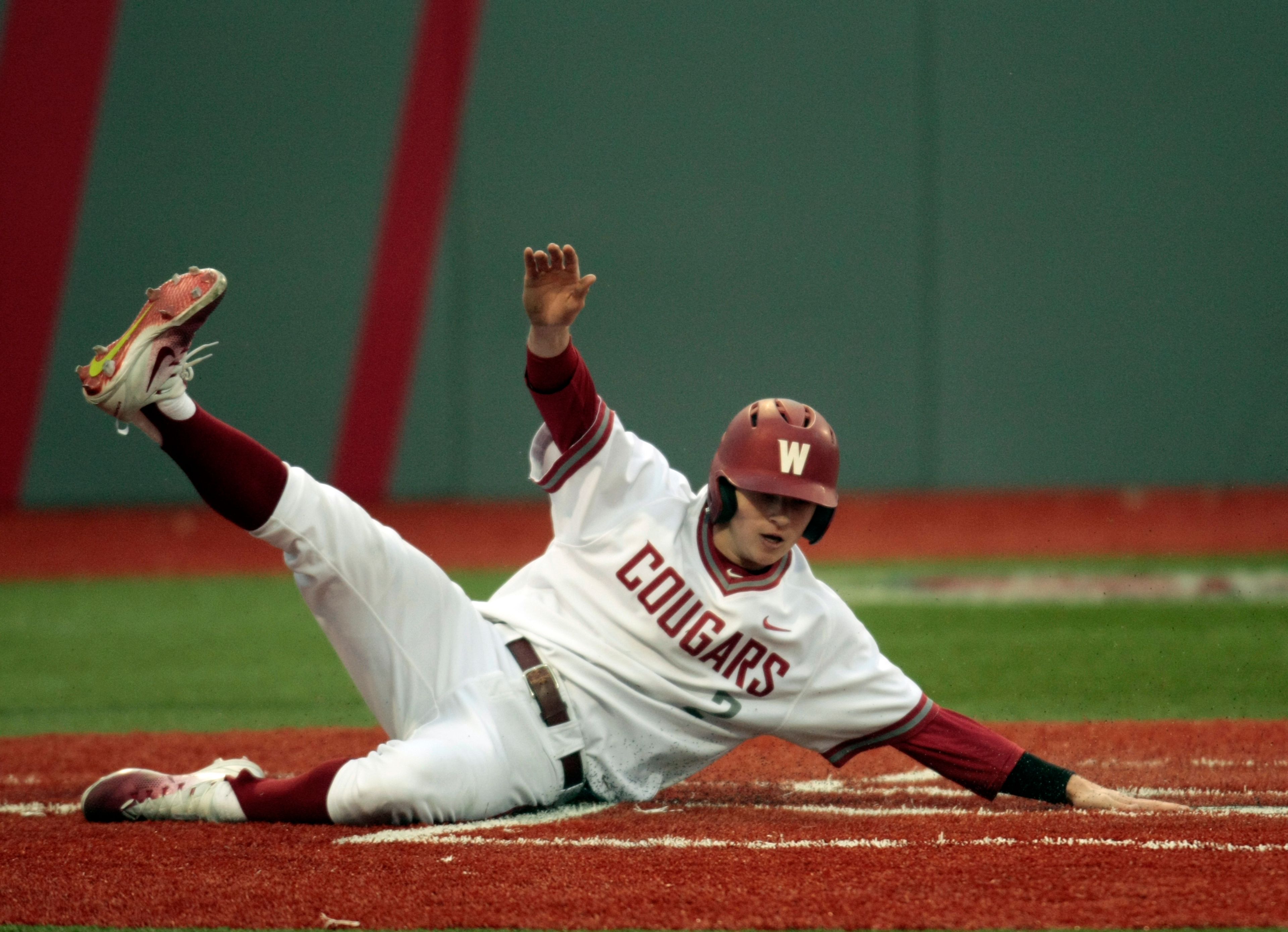 Washington State freshman Danny Sinatro slides across home plate to score against Arizona on Friday evening at Bailey Brayton Field.