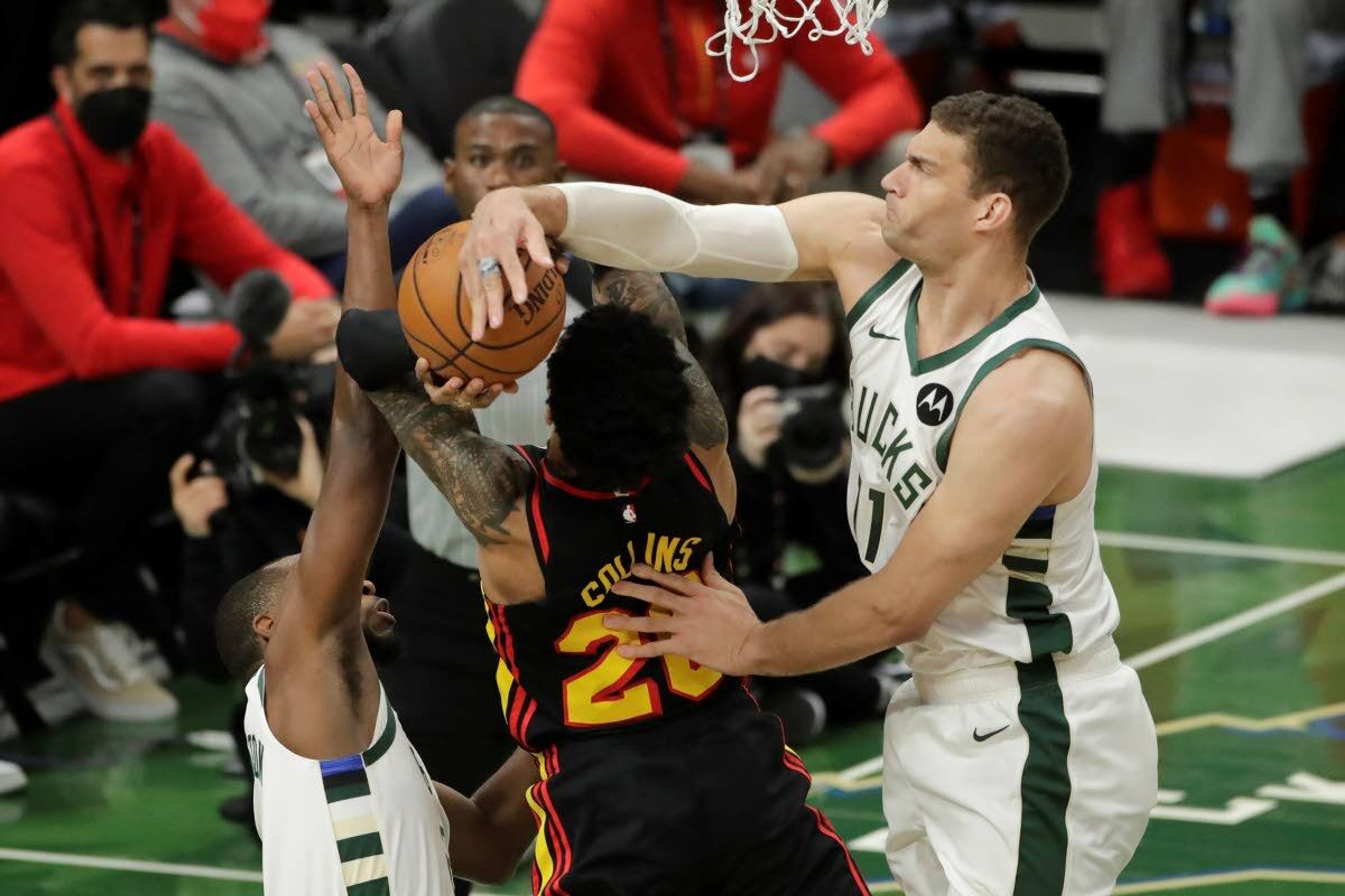 Milwaukee Bucks' Brook Lopez, right, blocks a shot attempted by Atlanta Hawks' John Collins, center, during the first half of Game 5 of the NBA Eastern Conference Finals Thursday, July 1, 2021, in Milwaukee. (AP Photo/Aaron Gash)