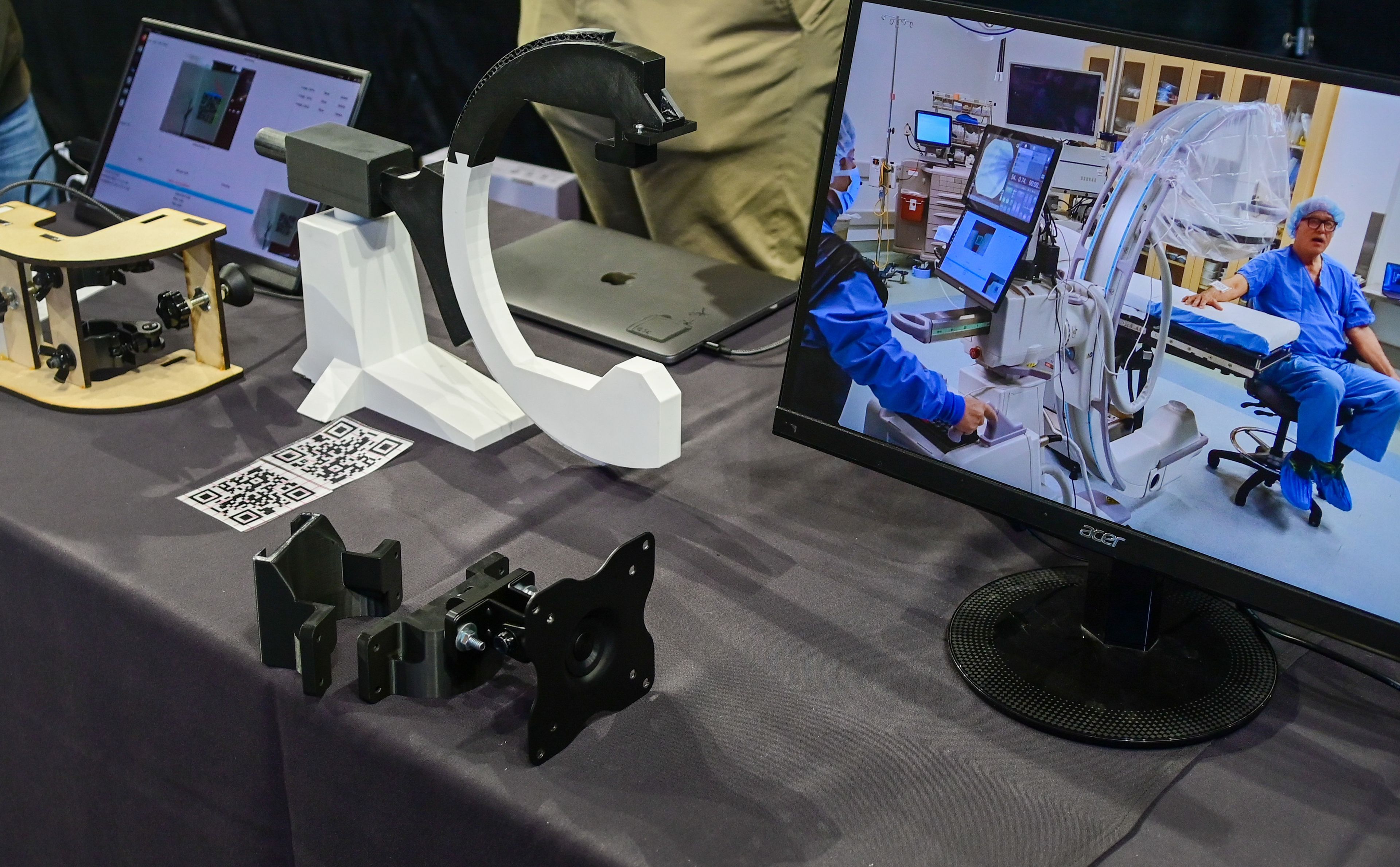 A small C-Arm medical imaging model sits next to a video showing a new relocation guidance system for the machine in use at the Engineering Design EXPO capstone presentations in Moscow on Friday.