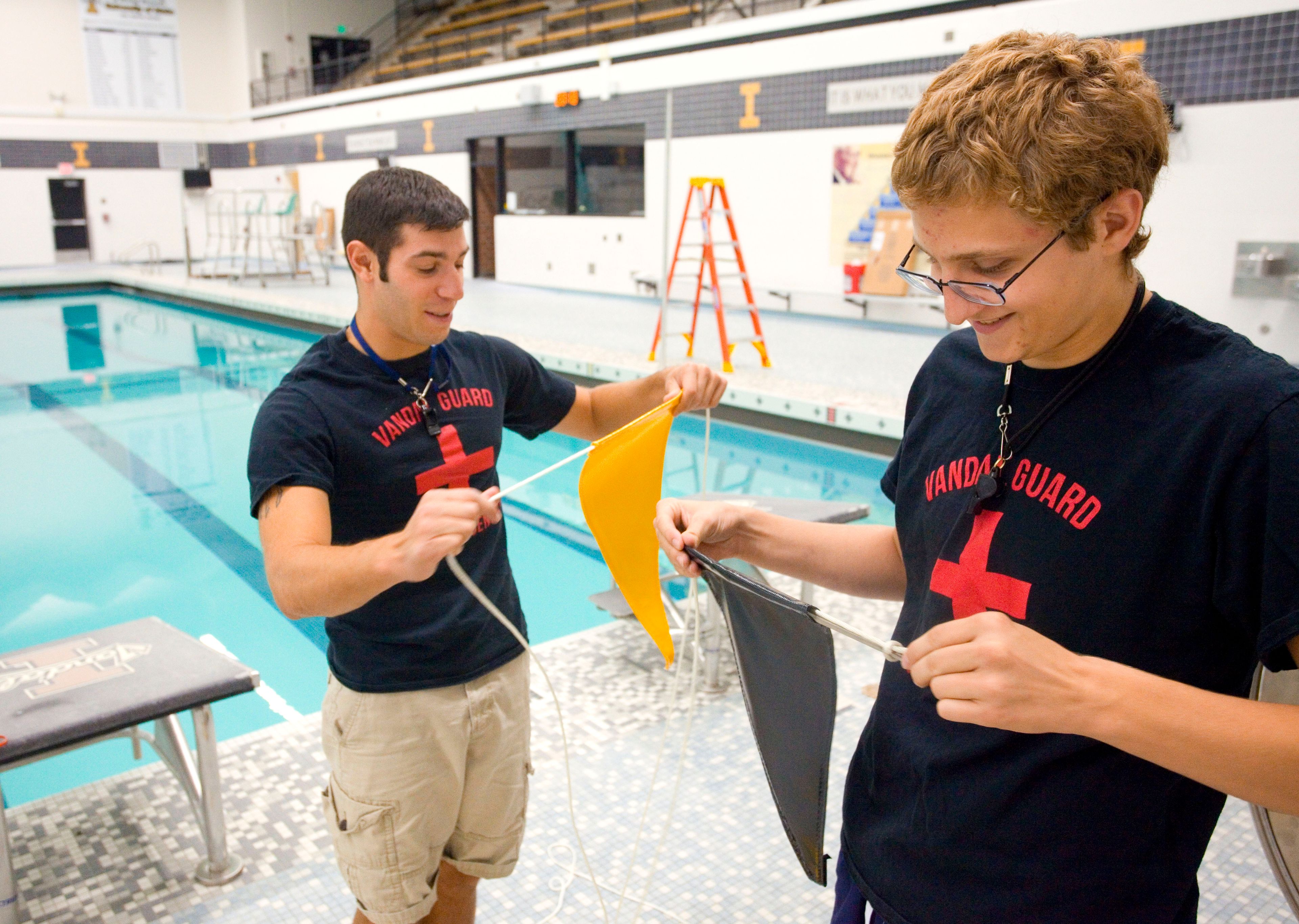 University of Idaho Swim Center employees John Alberts, left, and Spencer string new backstroke flags onto a rope on Thursday in Moscow. The swim center is scheduled to open on Monday after being closed for the summer for a $1 million renovation that included replacing the ceramic tiles in both pools and part of the pool deck.