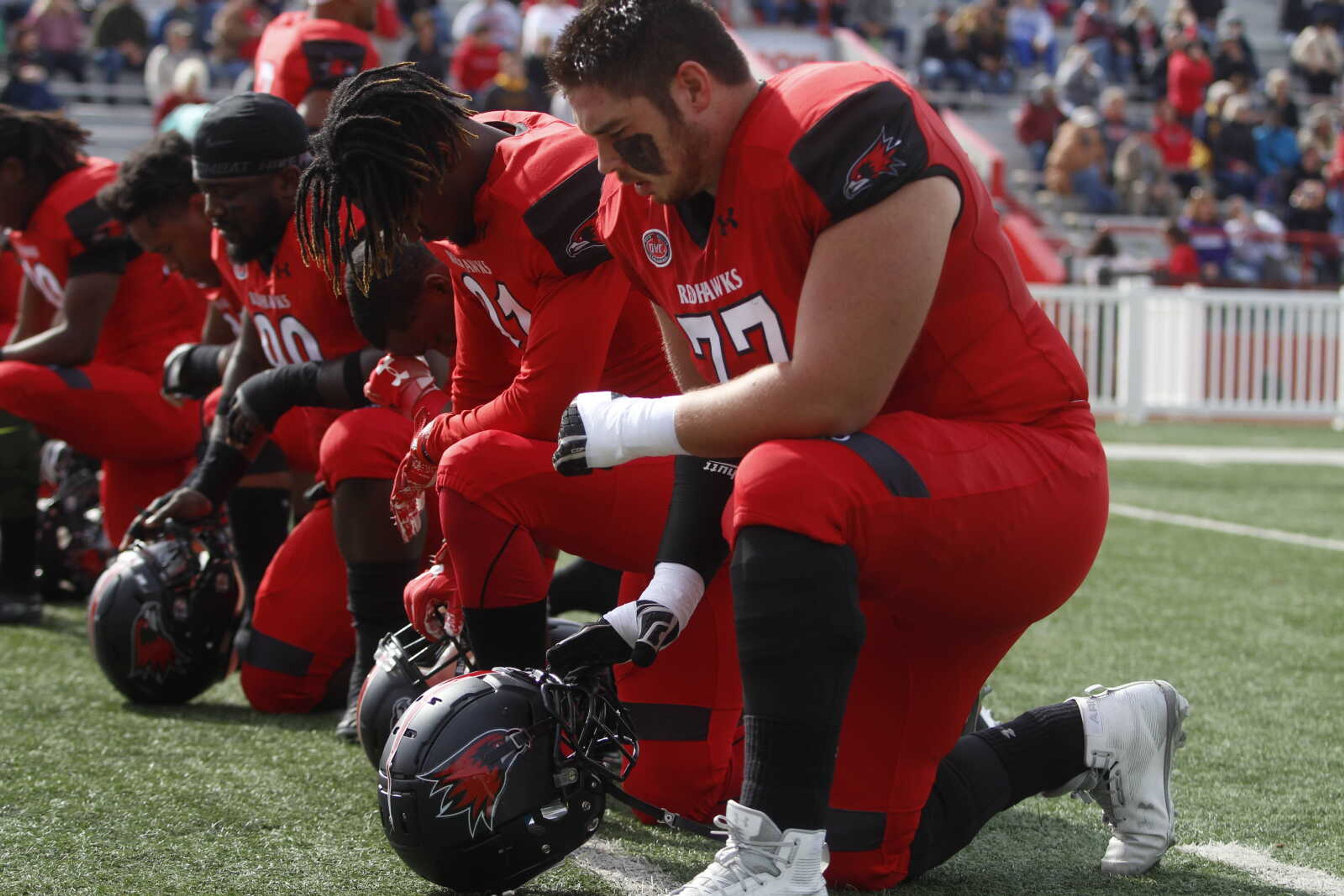 Several Redhawks take a knee prior to the start of the game against Tennessee State on Nov. 3, including junior offensive lineman Elijah Swehla (right).