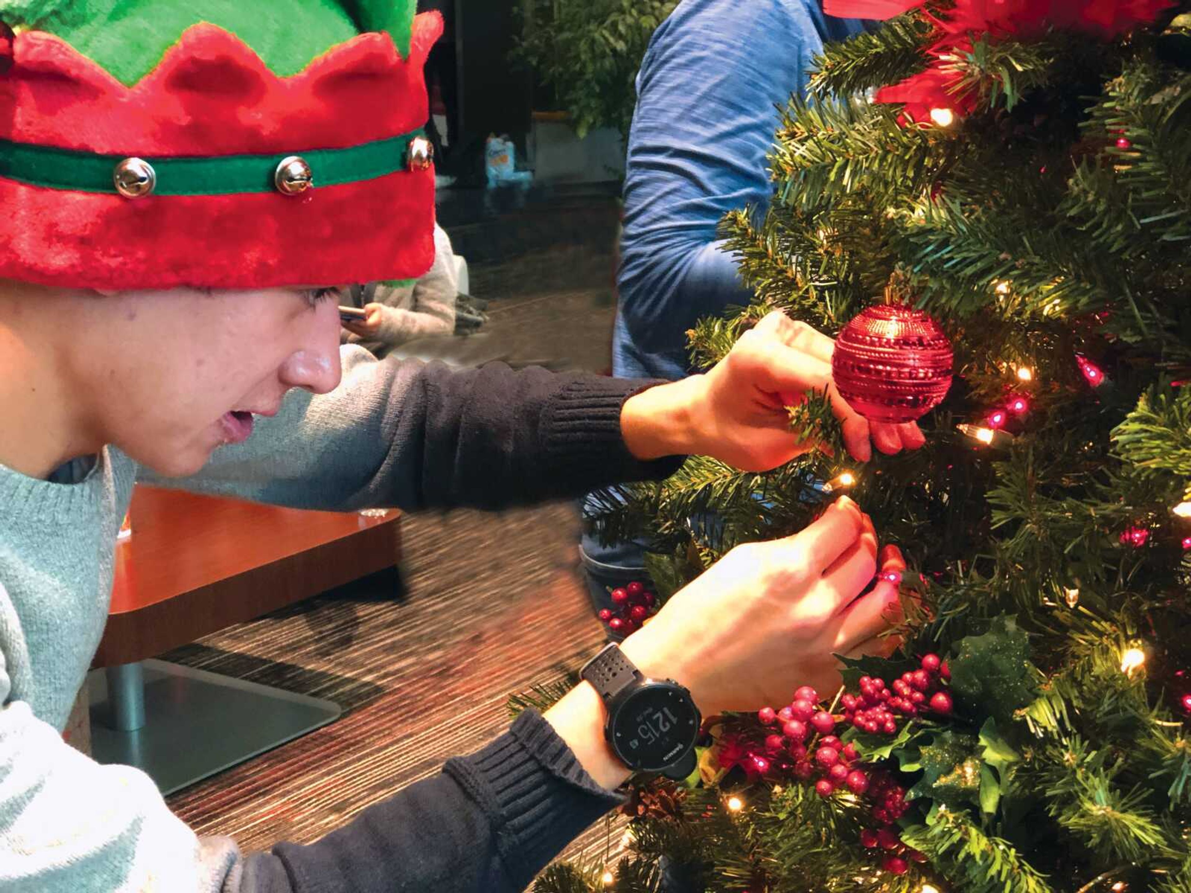 Sophomore Chris Durr carefully places an ornament on the Christmas tree located on the third floor of the U.C.
