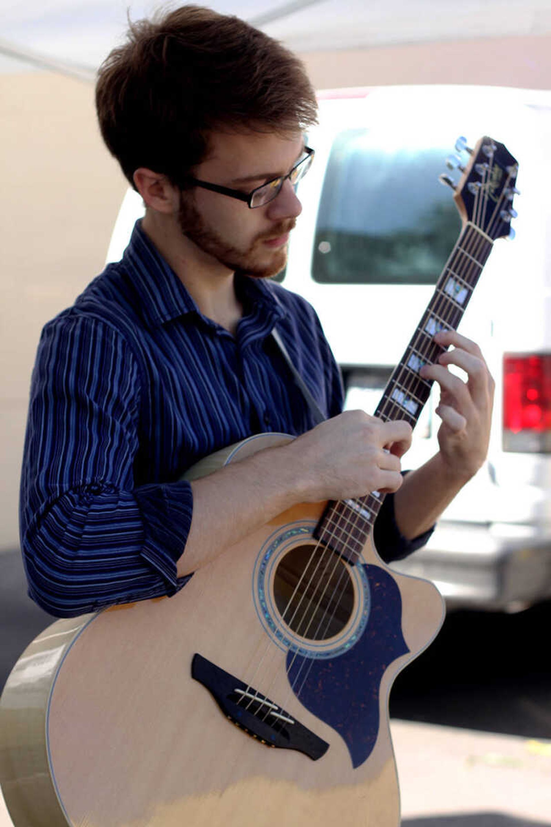 Southeast student Jacob Seyer plays a song at the Cape Girardeau Riverfront Market. Photo by Brittany Thomsen