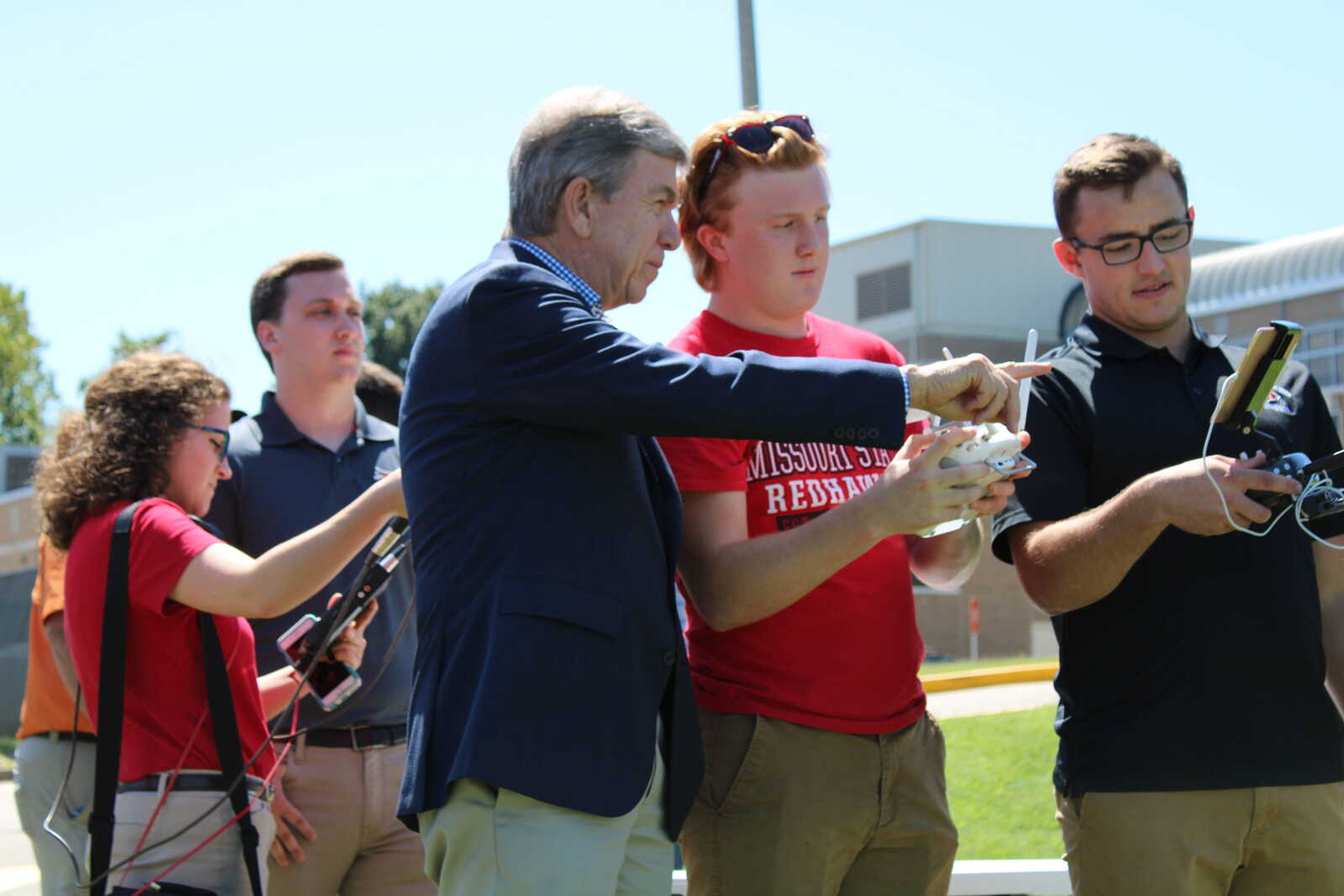Seniors (left) Nathan McKlin and (right) Brigham Haase show Senator Roy Blunt how to operate a drone on the practice field on Thursday, Aug. 29.