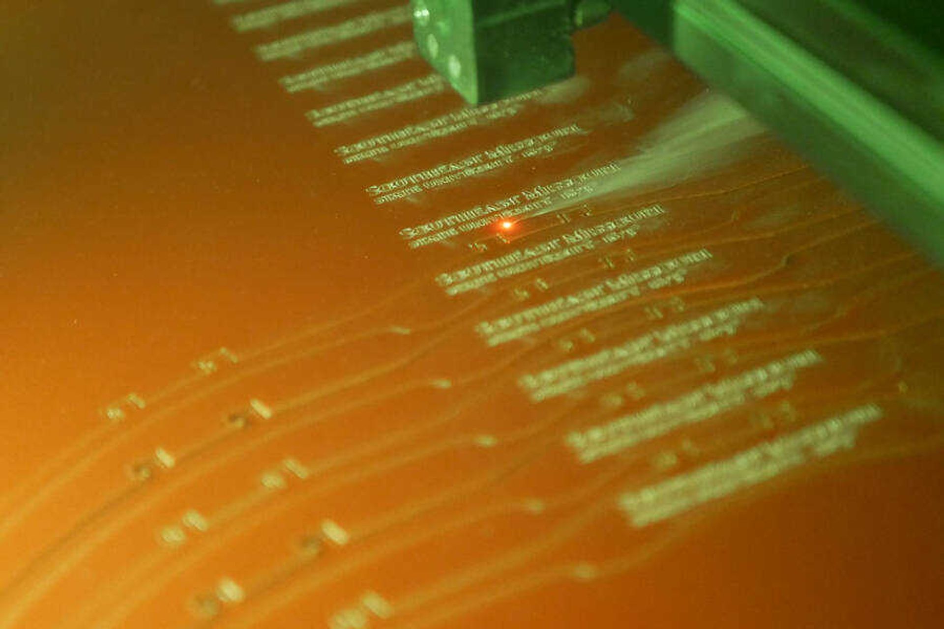 A laser carves out engraved headbands for face shields that will be distributed to staff members on campus. The face shields were made by employees at Seabaugh Polytechnic Building.