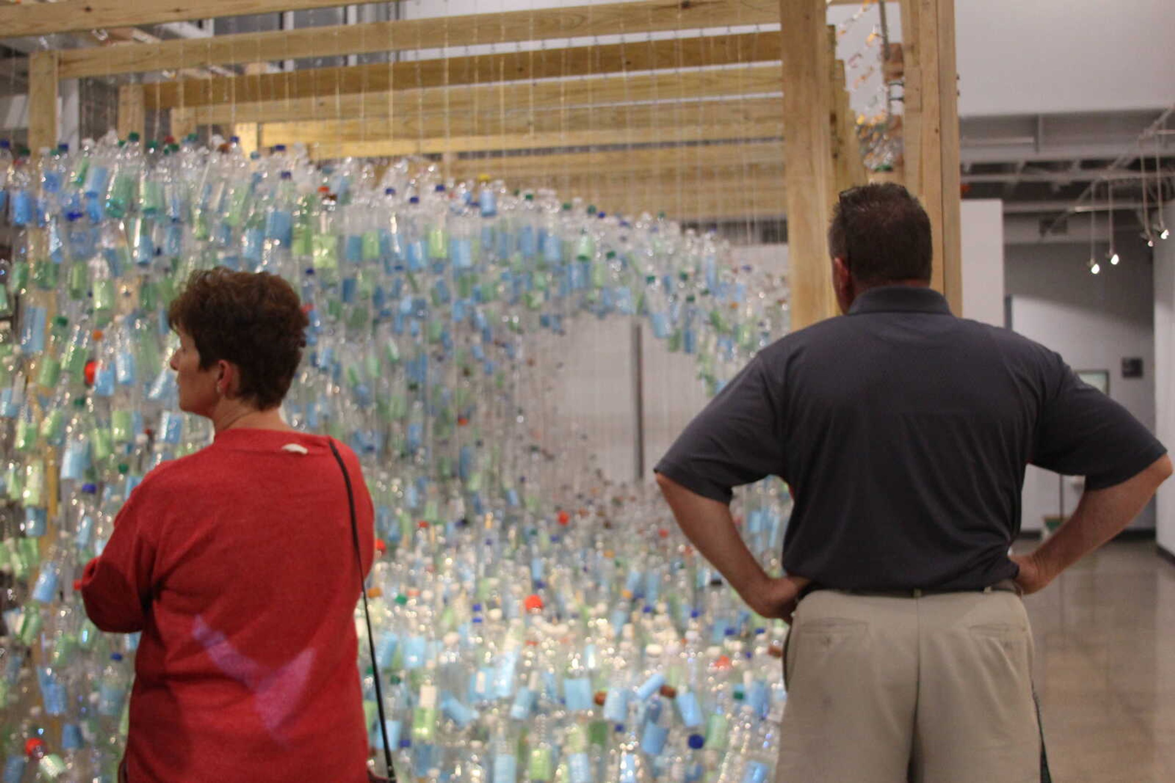 Patrons observe Kevin Hand’s “Wave of Emotion” at Catapult Creative House on Sept. 7.