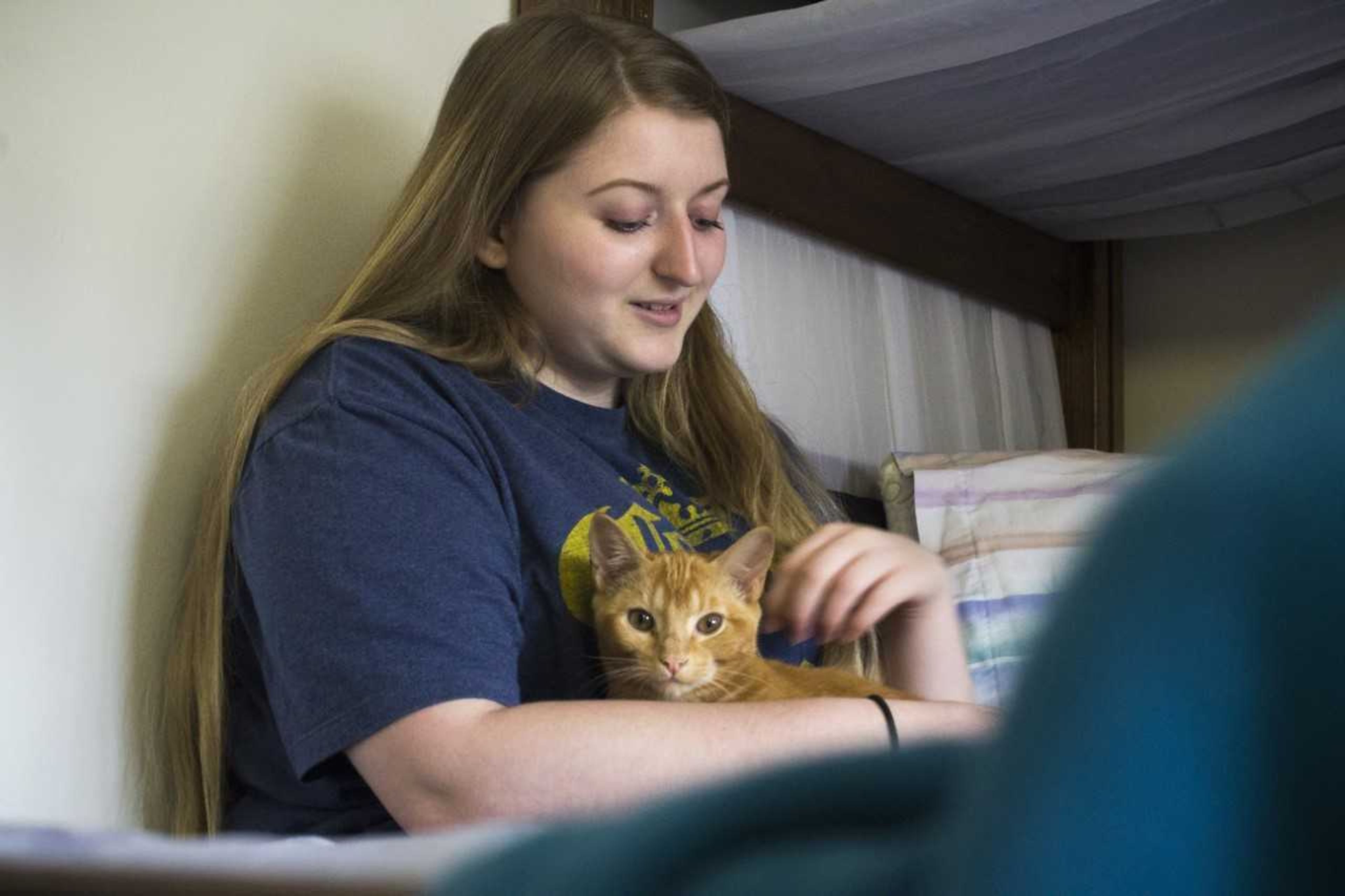 Rachel Rigney sits in her dorm in Myers holding Ollie, who shares her room with her.
