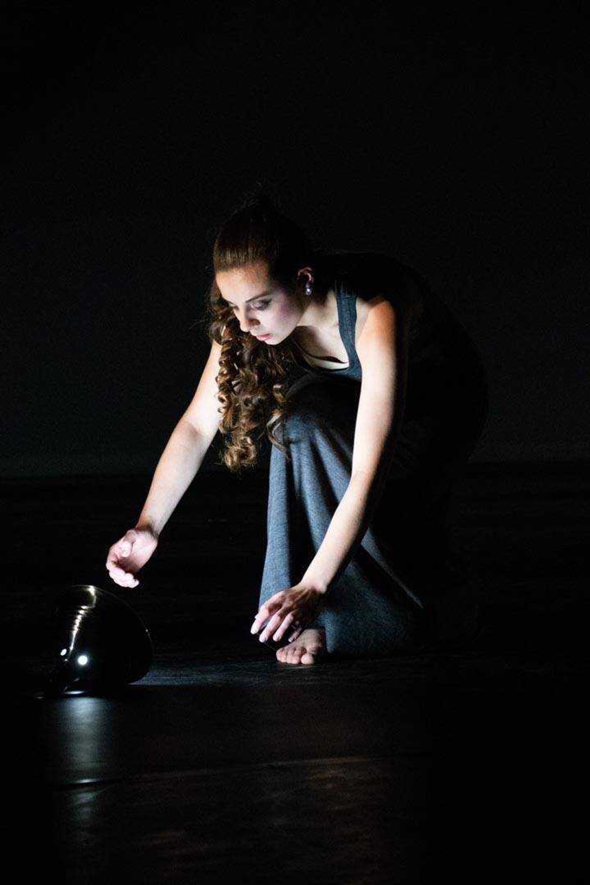 Senior Emilia Schempp works with her prop, a lamp, in "Silent Language," choreographed by guest artist Jennifer Mabus, during a Spring into Dance dress rehearsal.