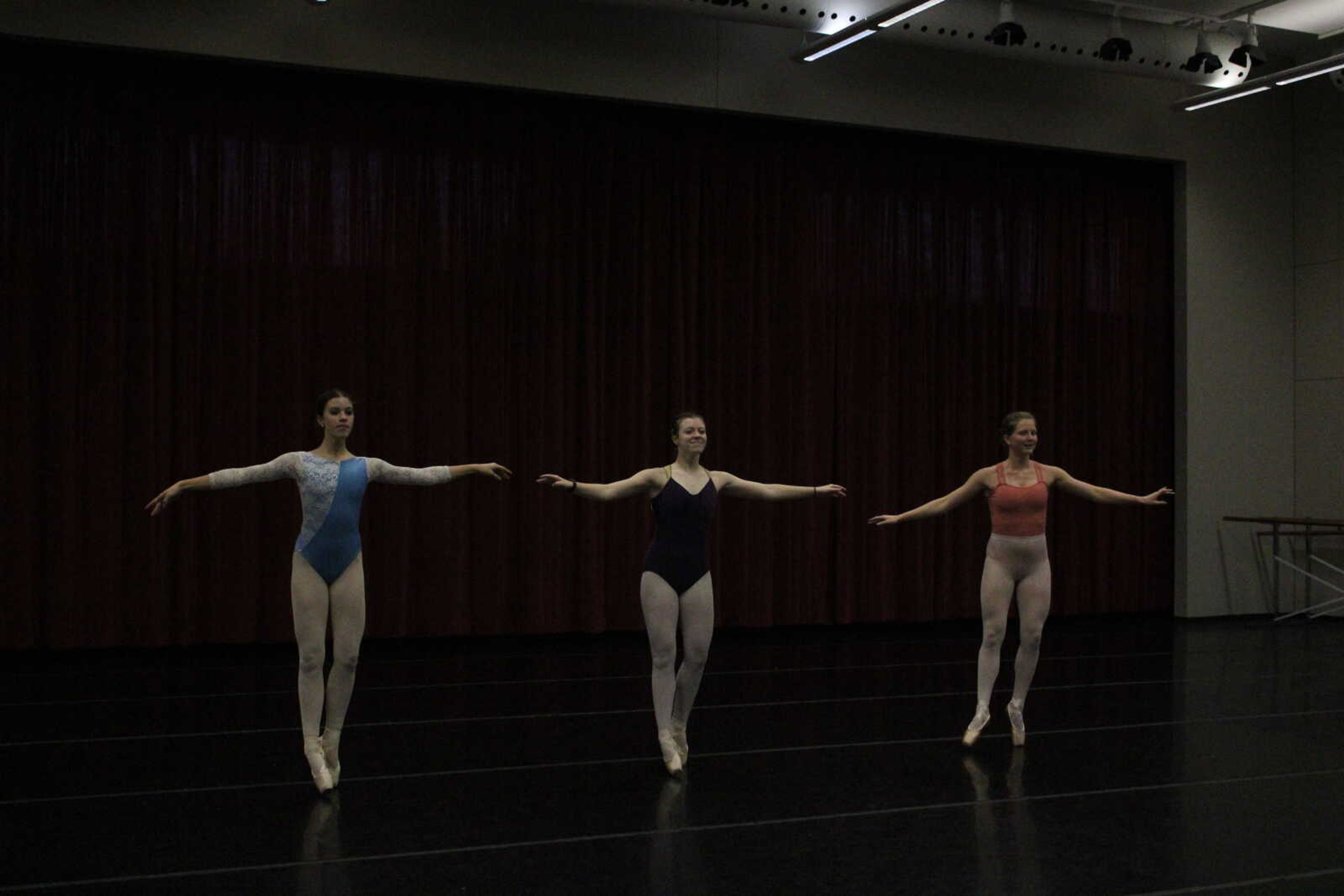 (Left) Grace Petzoldt, Evelyn Bunce and Olivia Barnard smile and hold the same pose, hands outstretched as they practice for Fall for Dance. 