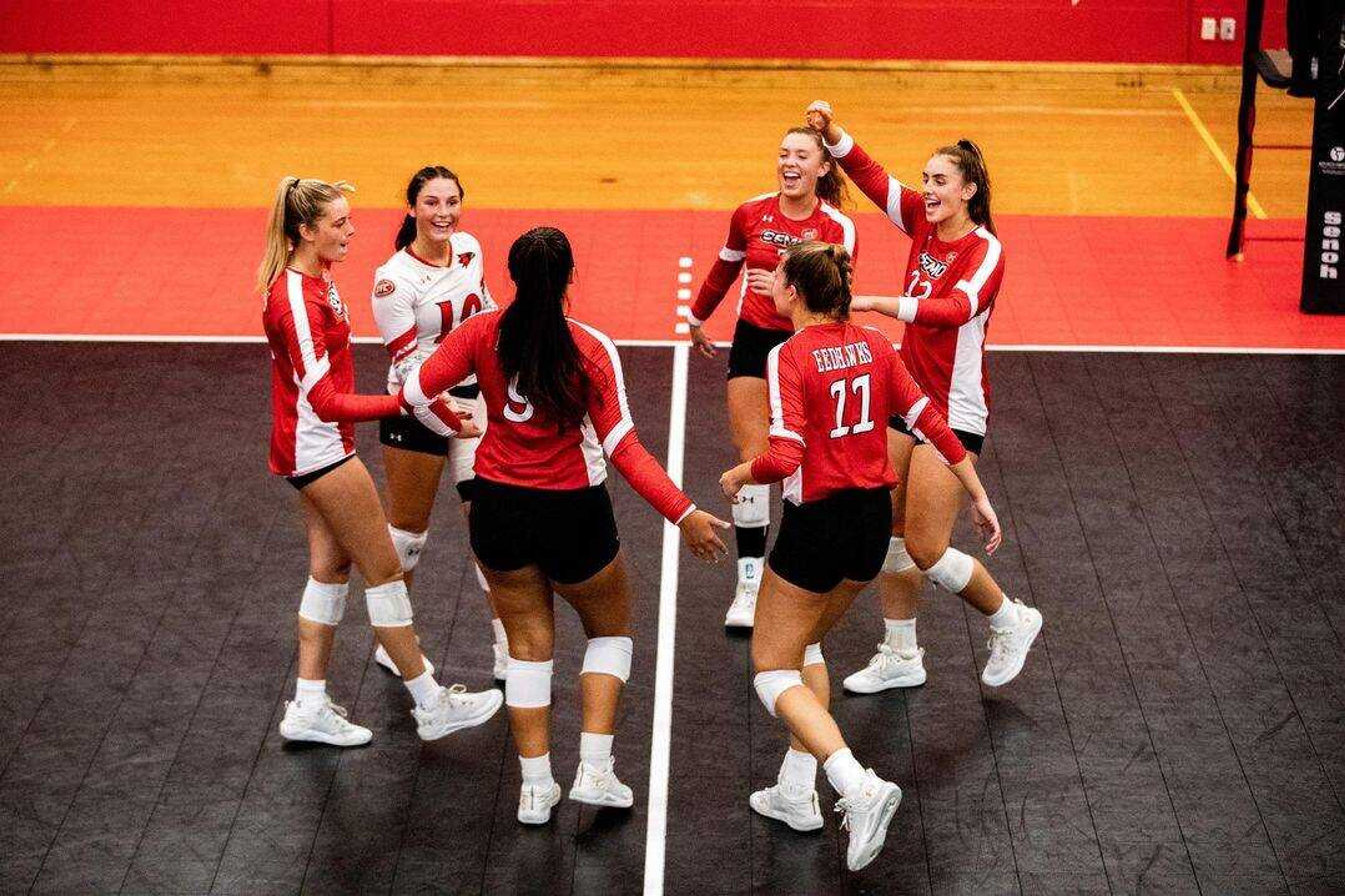 The Redhawk volleyball team celebrates after scoring a point on Saturday, Sept. 24 at Houck Field House.