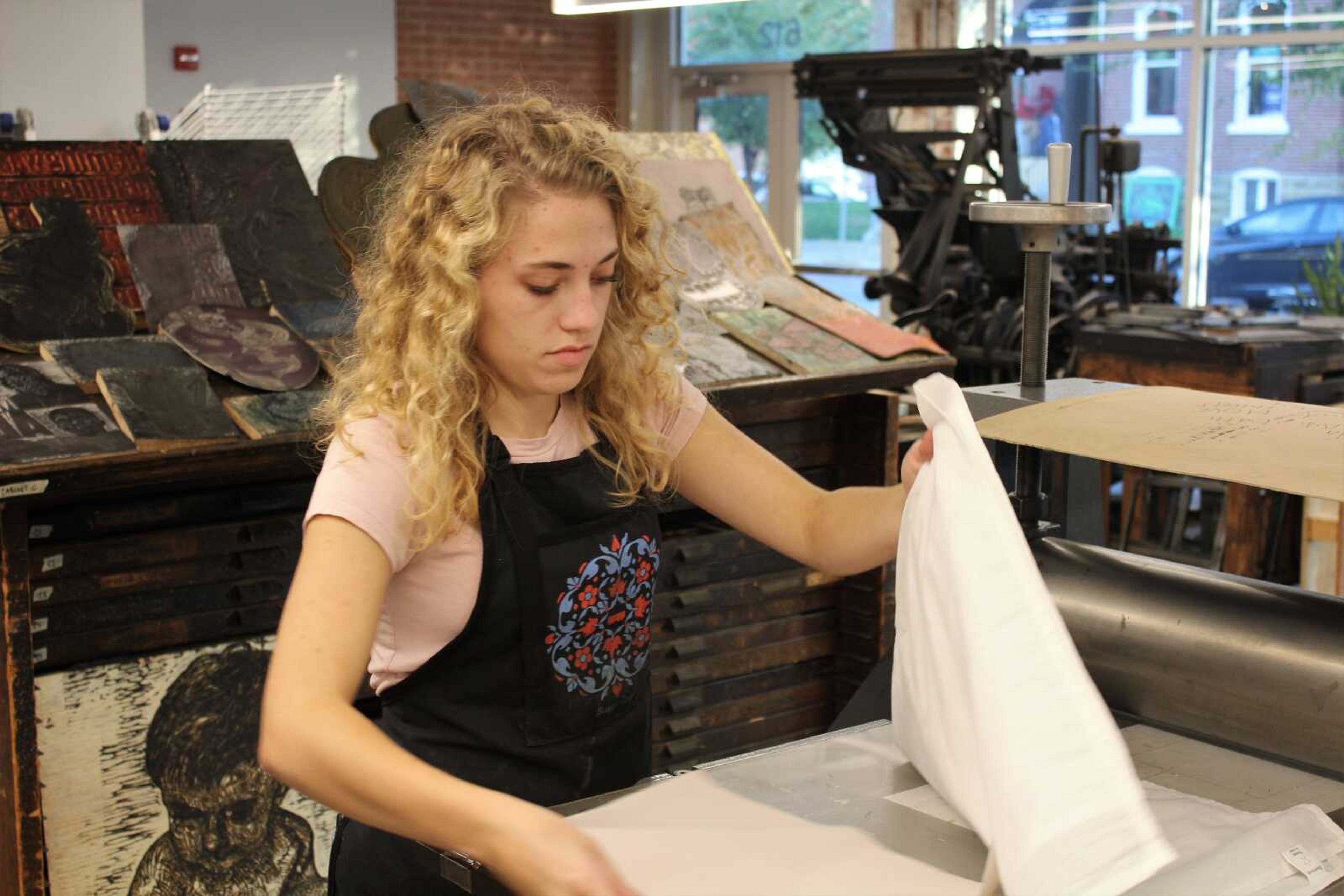 Senior, Jessica Lambert sets up pieces of paper before beginning an art project at Catapult Creative House during First Friday with the Arts on Nov. 3.