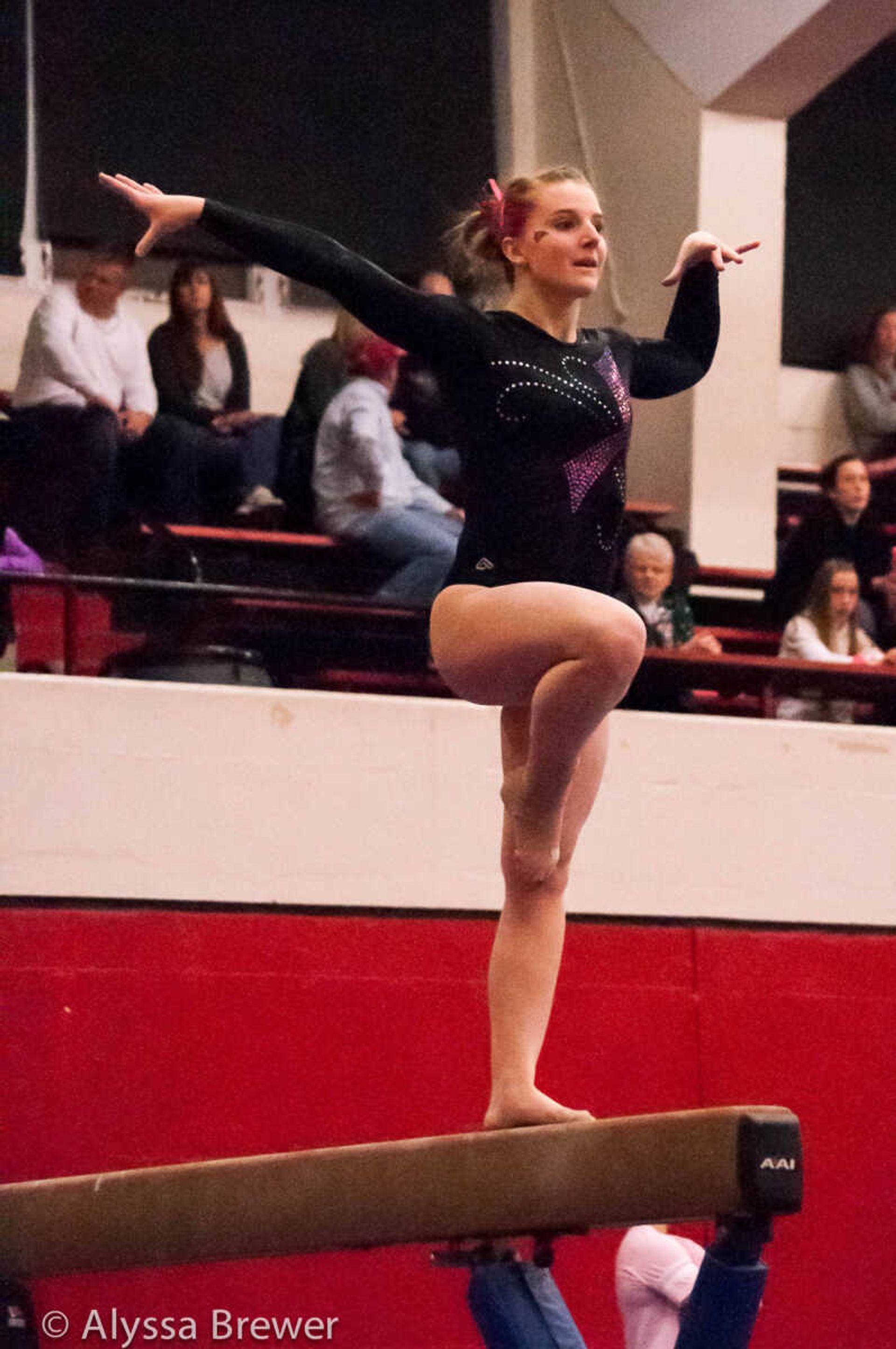 A Redhawks gymnast performs a routine on the balance beam during a competition.