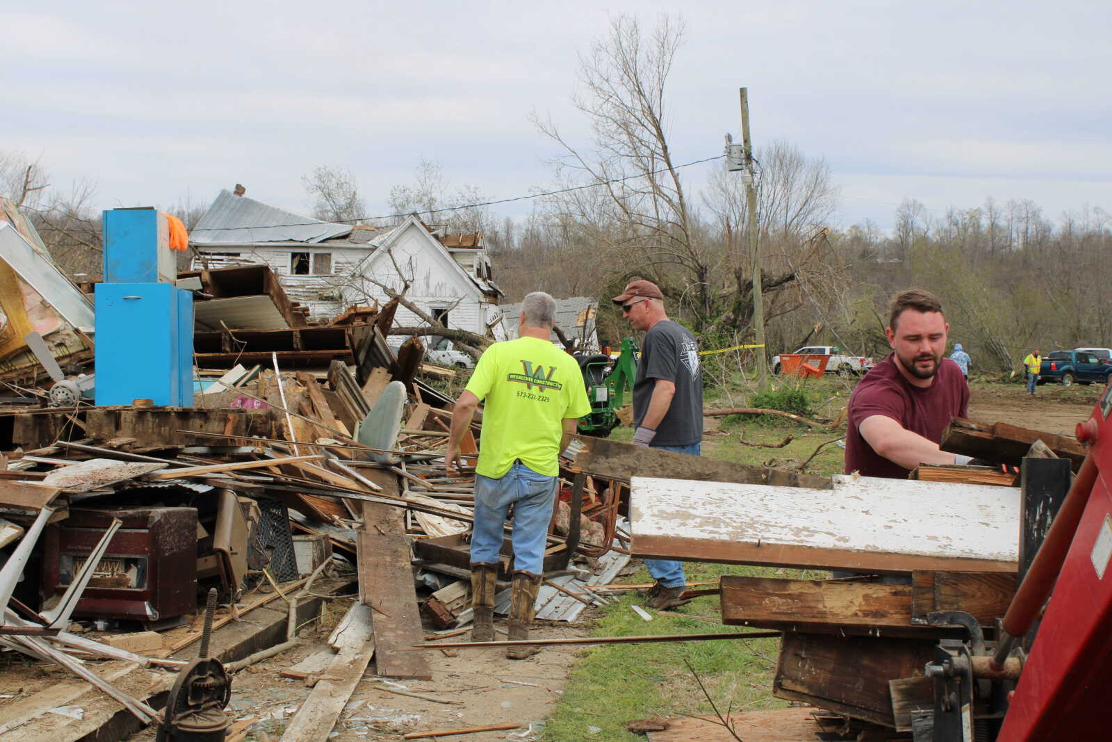Joshua Wells (front) helps Phil Stanfill (left) and Tony Jansen (right) remove a wall from the Stanfills' collapsed house. The building was the third oldest in town, according to Patty Stanfill.
