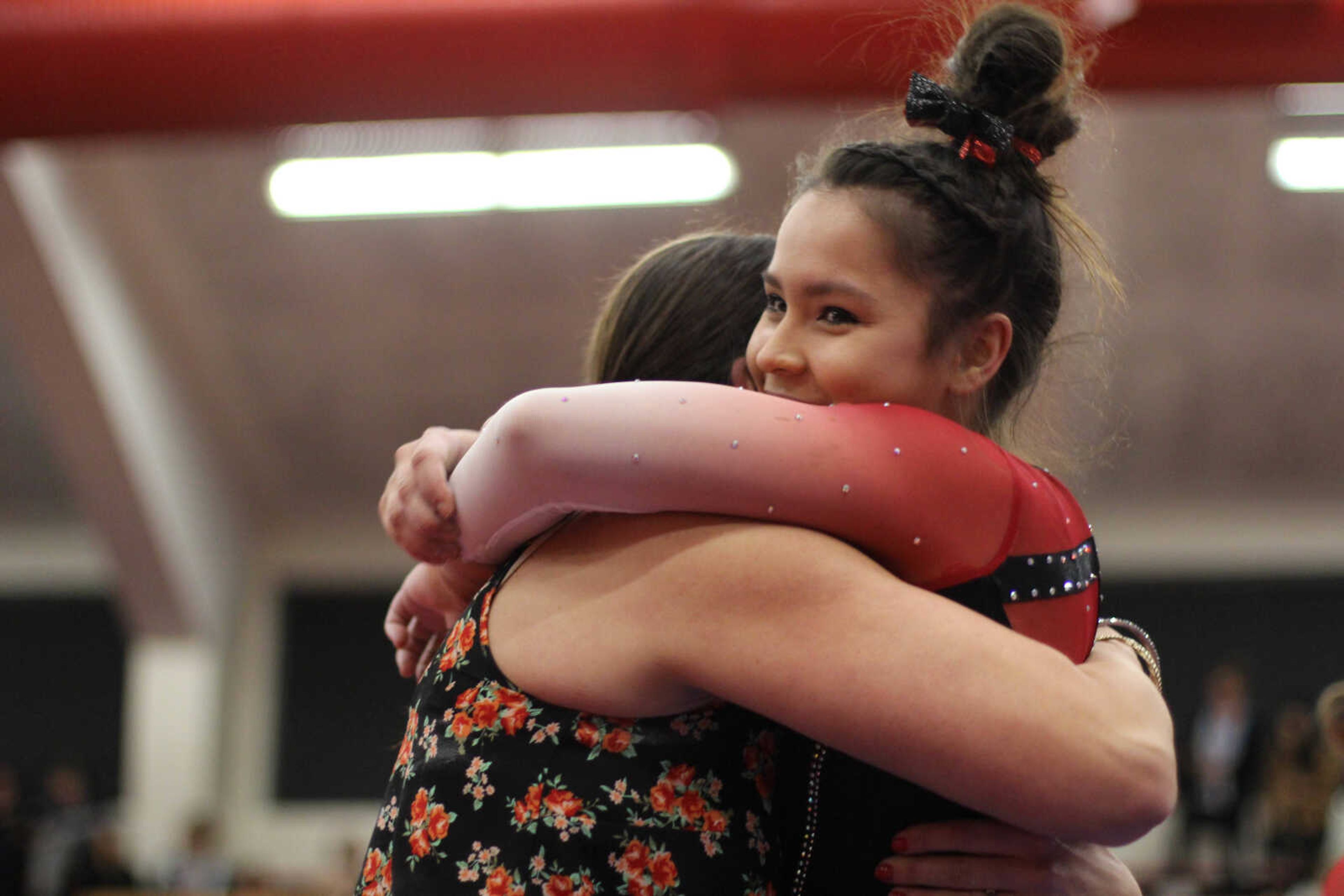Freshman Anna Kaziska embraces Southeast coach Ashley Lawson after performing her beam routine on March 1 at Houck Field House.