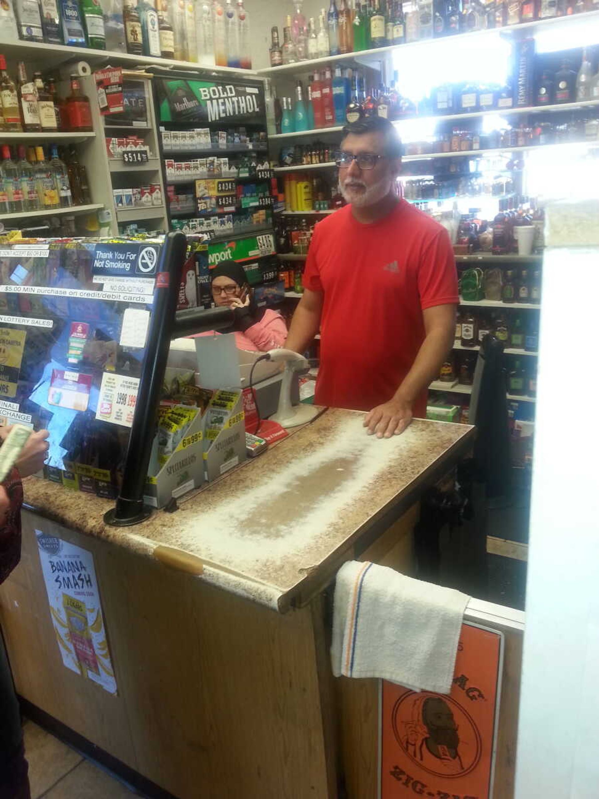 Asif “Steve” Majeed, the owner of SEMO gas, works behind the counter of his gas station and convenience store.