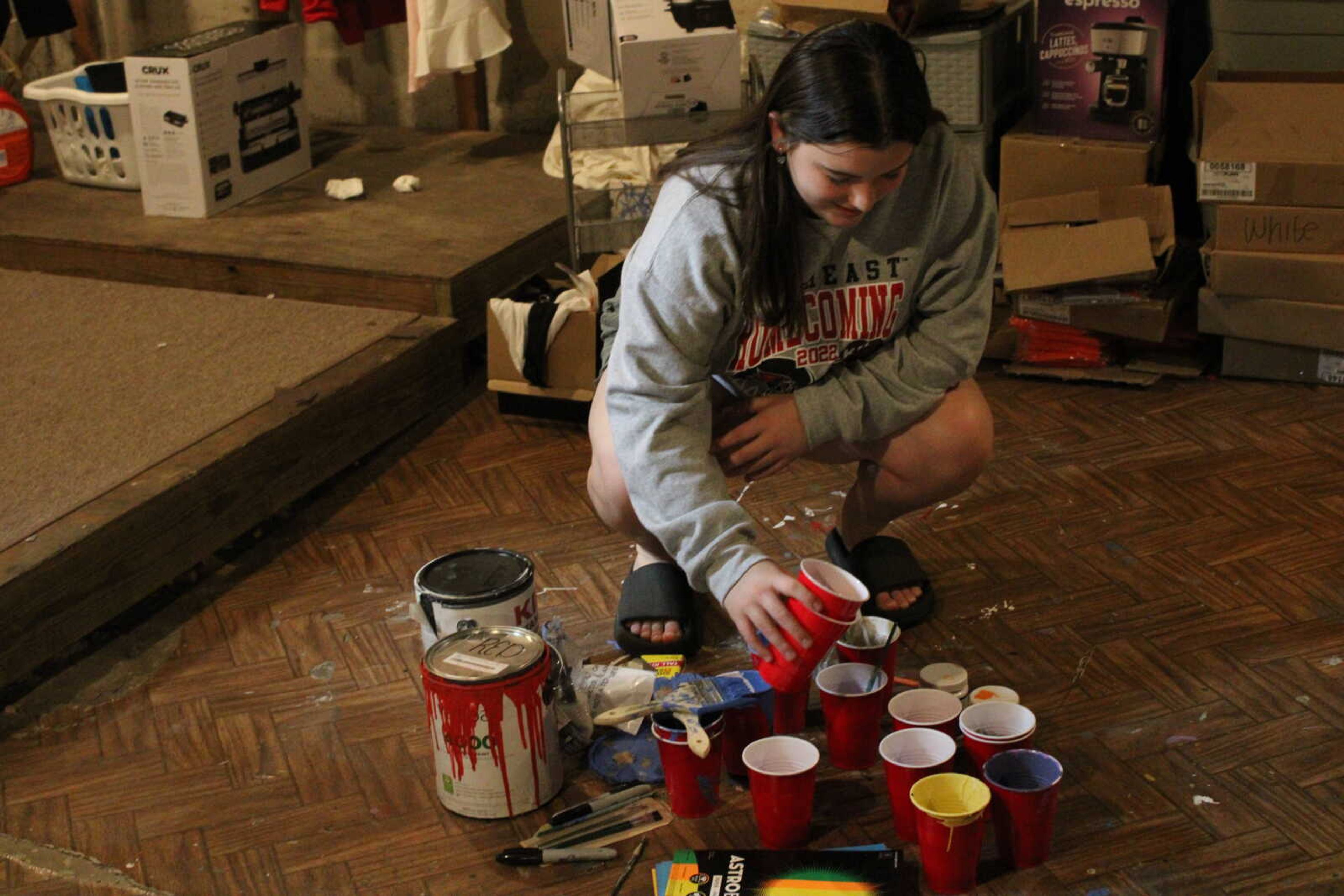 Junior occupational therapy major and Delta Delta Delta (Tri Delta) Homecoming chair Mikayla Beachle organizes the pomping and painting supplies in the basement of the Tri Delta off-campus house. "It's rewarding to just see everybody working together," Beachle said.
