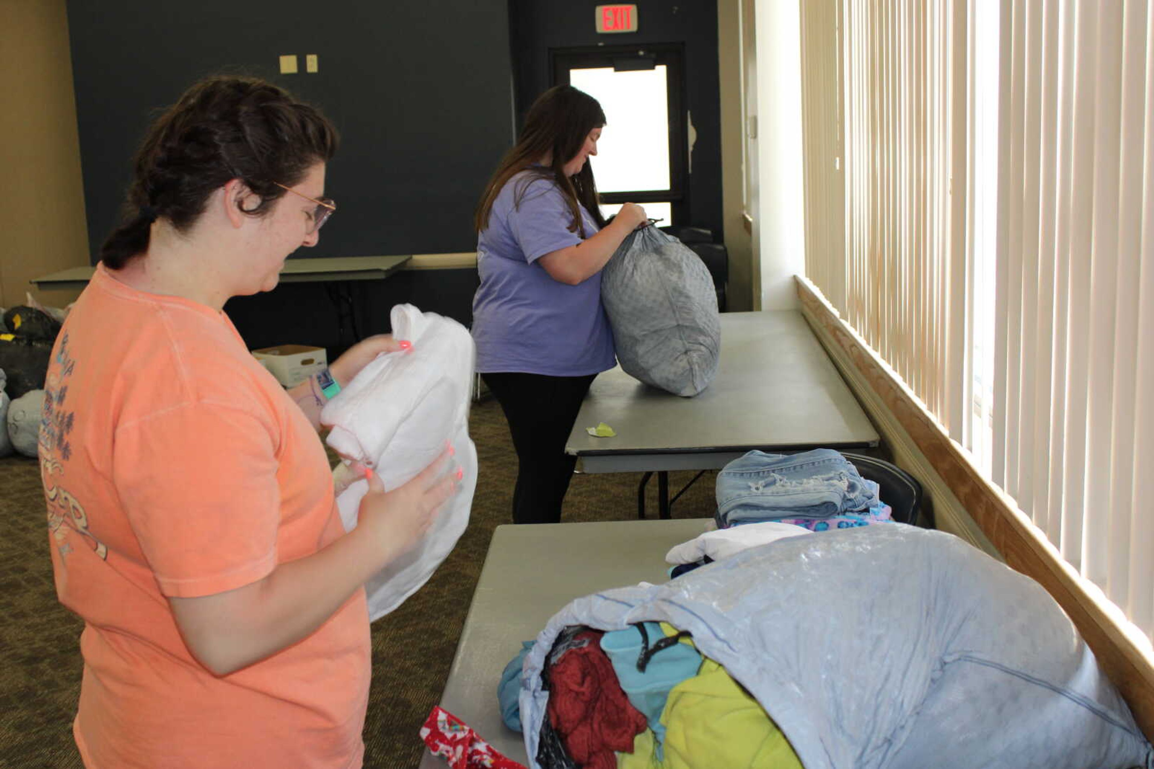 Two members of Greek Life work to bag clothes donated during the Greek Week clothing drive.