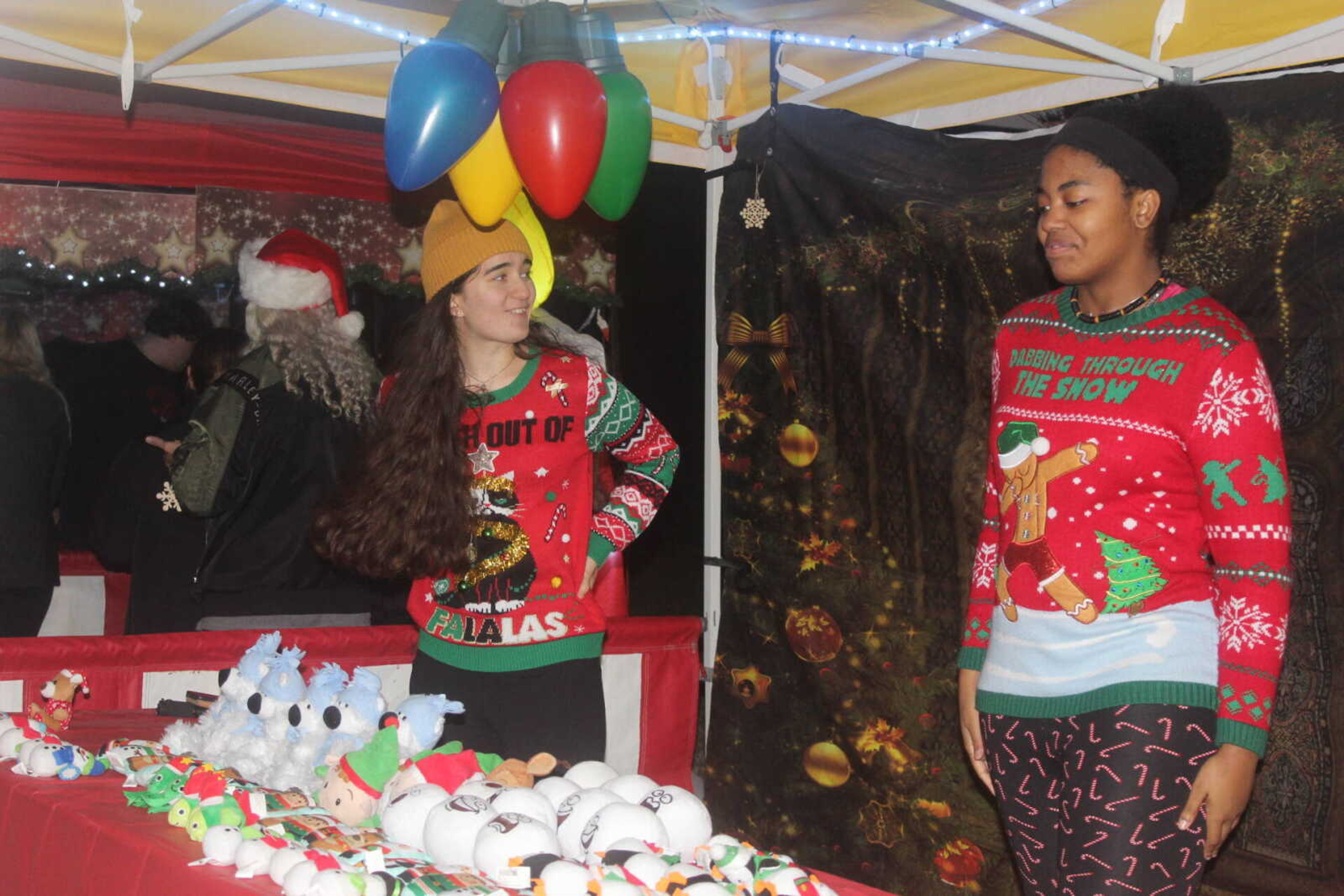 Two students man the festive prize table at Winterfest. 
