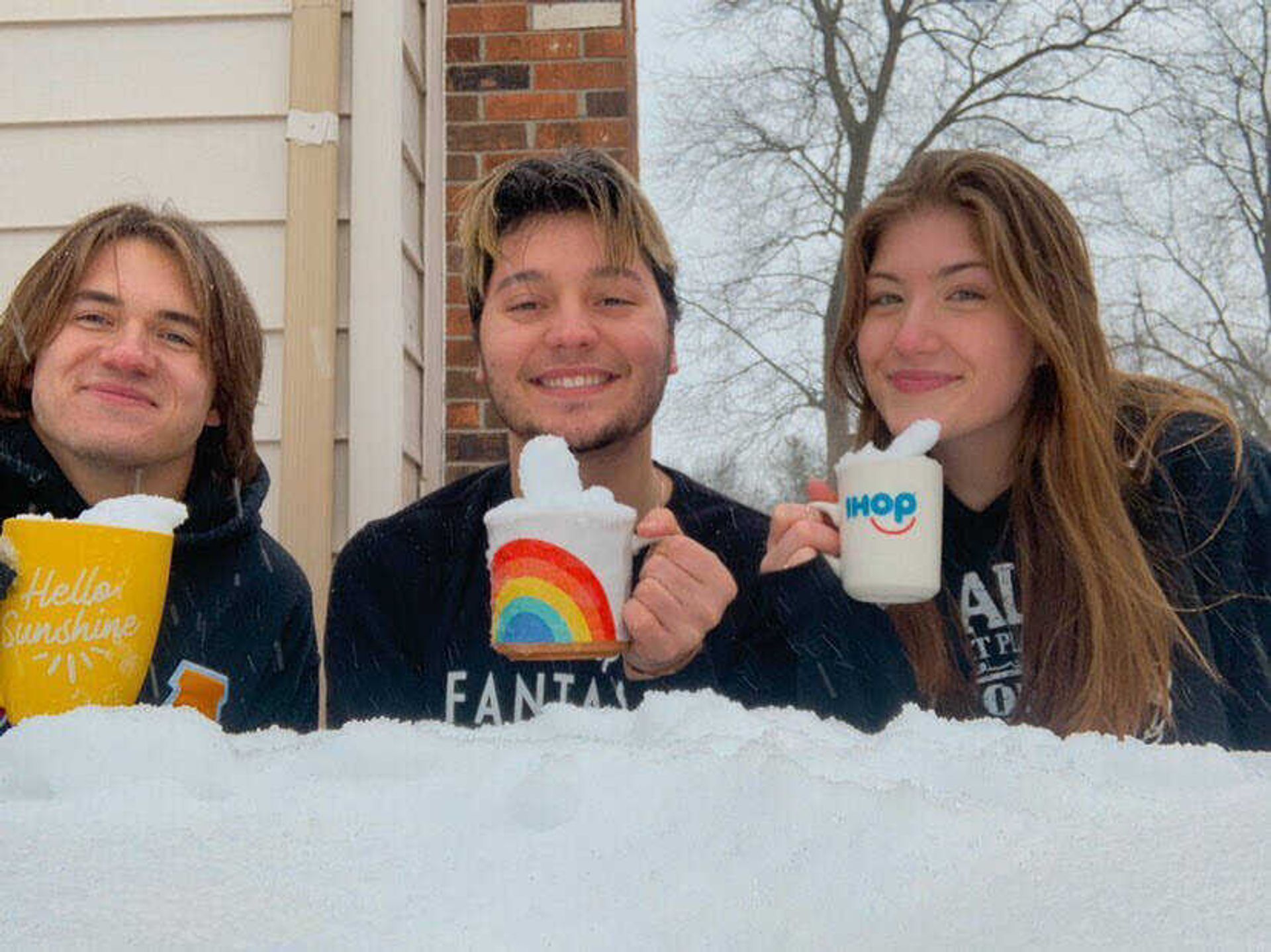 Students AJ Haessly, Anthony Kandilaroff and Shawna Creaser pose with mugs filled of snow. Many students used their time off from SEMO to hang out with friends.
