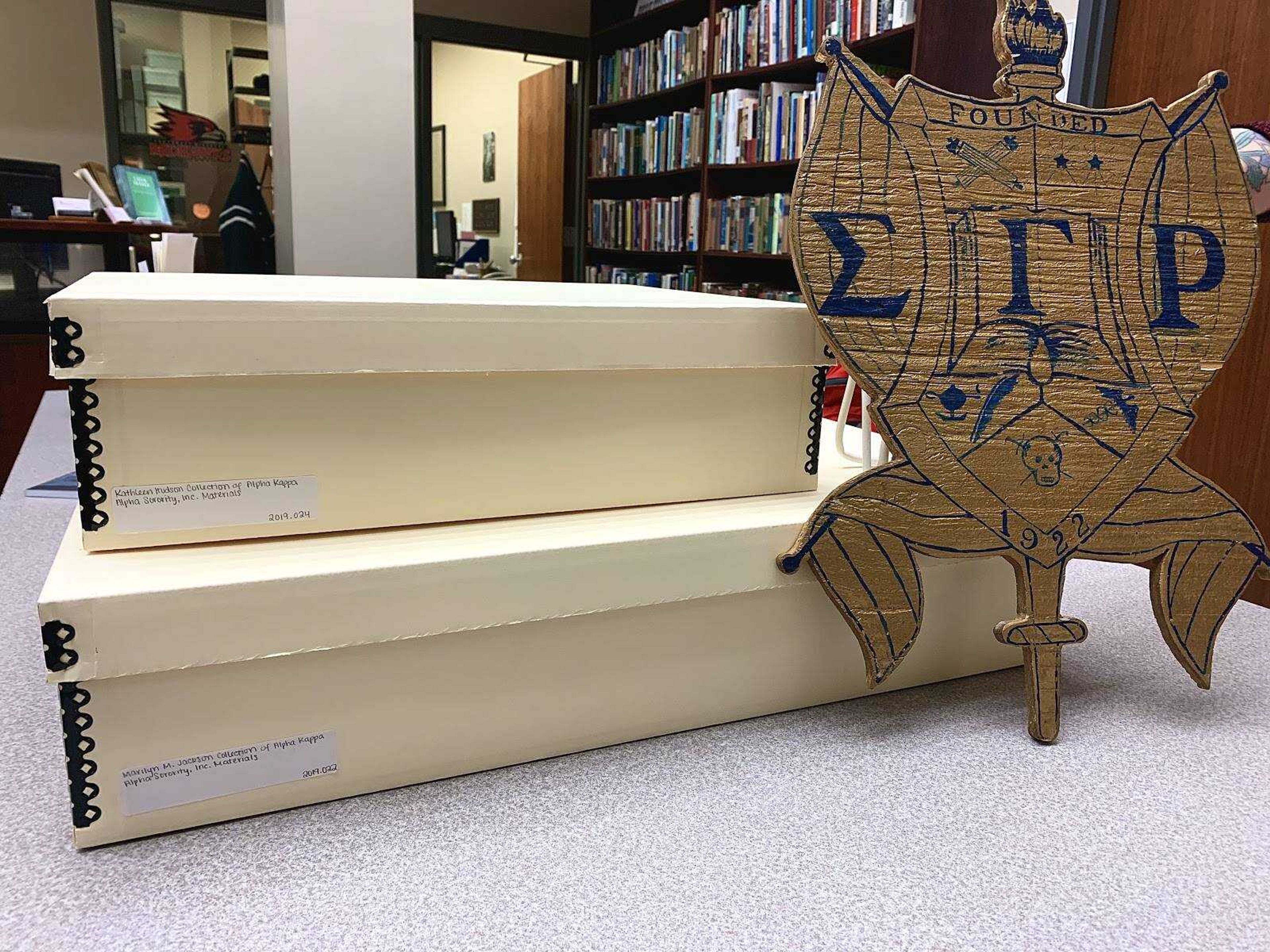 1922 Sigma Gamma Rho signage sits propped against donated African American greek memorabilia from Kathleen Hudson and Marilyn Jackson.